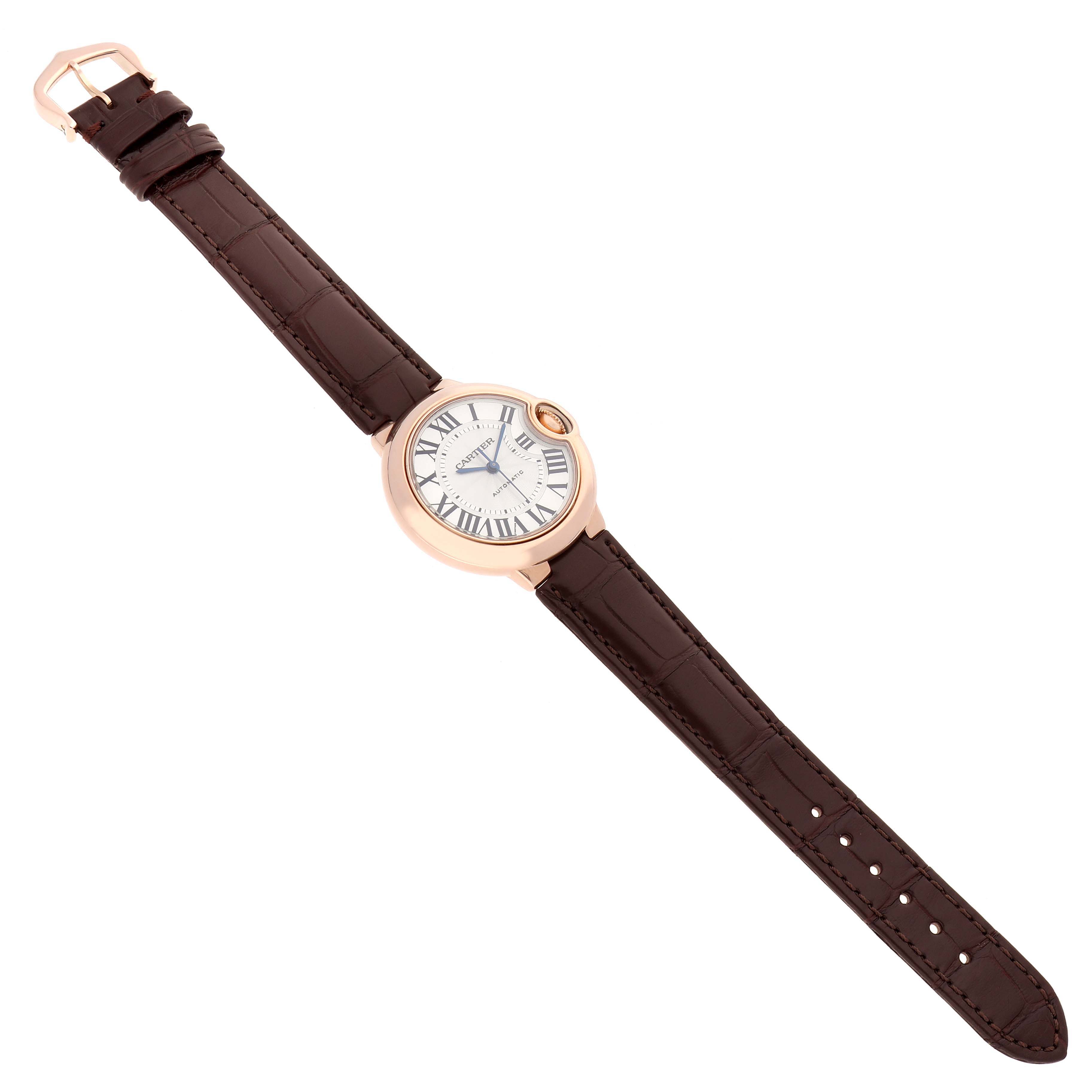 The Cartier Ballon Bleu W6920097 Women's Rose Gold Silver Dial watch is shown from a top-down angle, displaying the full face and brown leather strap.