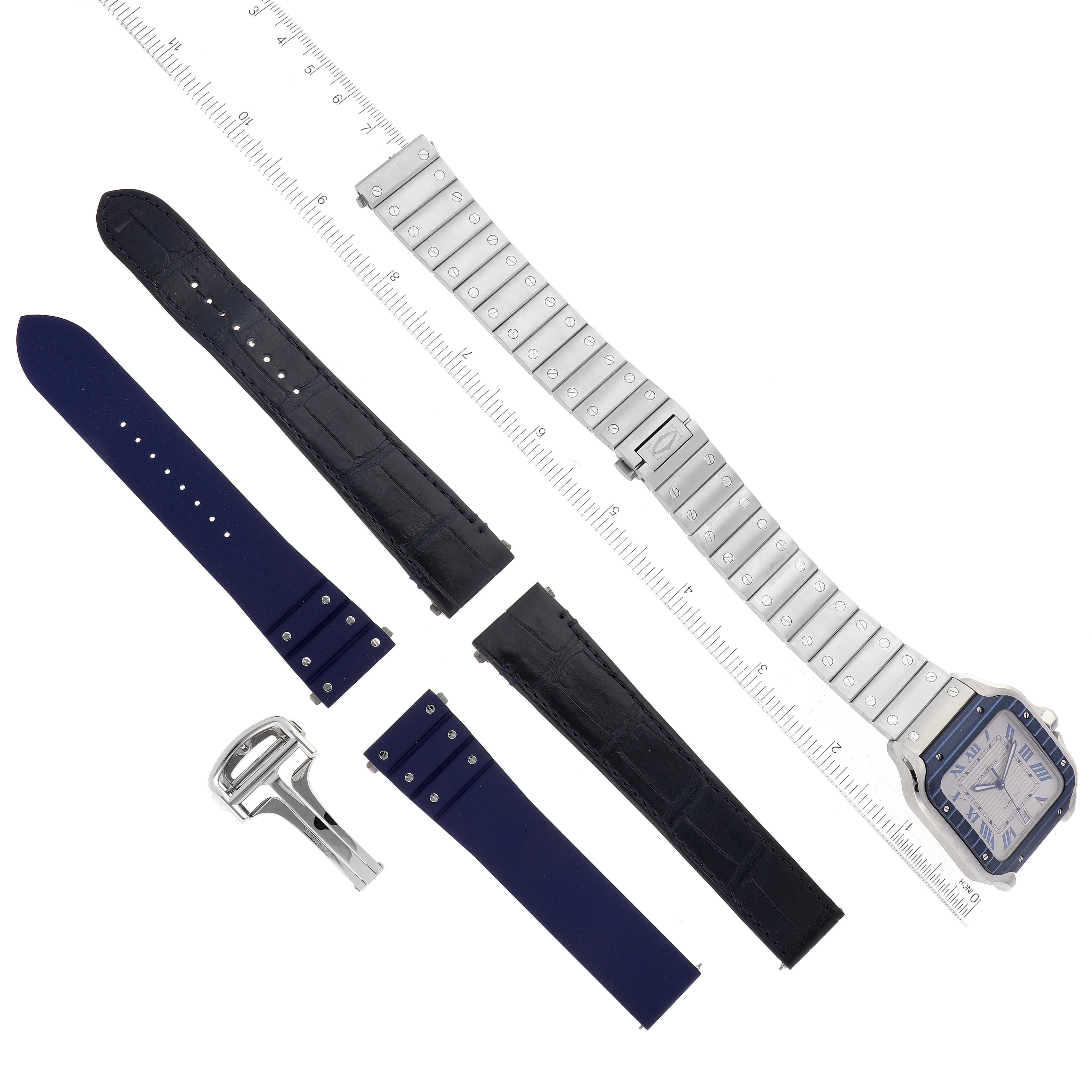 The image shows a Cartier Santos WSSA0047 Men
s Stainless Steel Silver Dial WSSA0047 Men
s Stainless Steel Silver Dial watch head with metal, leather, and rubber straps, along with a clasp, laid out on a ruler.
