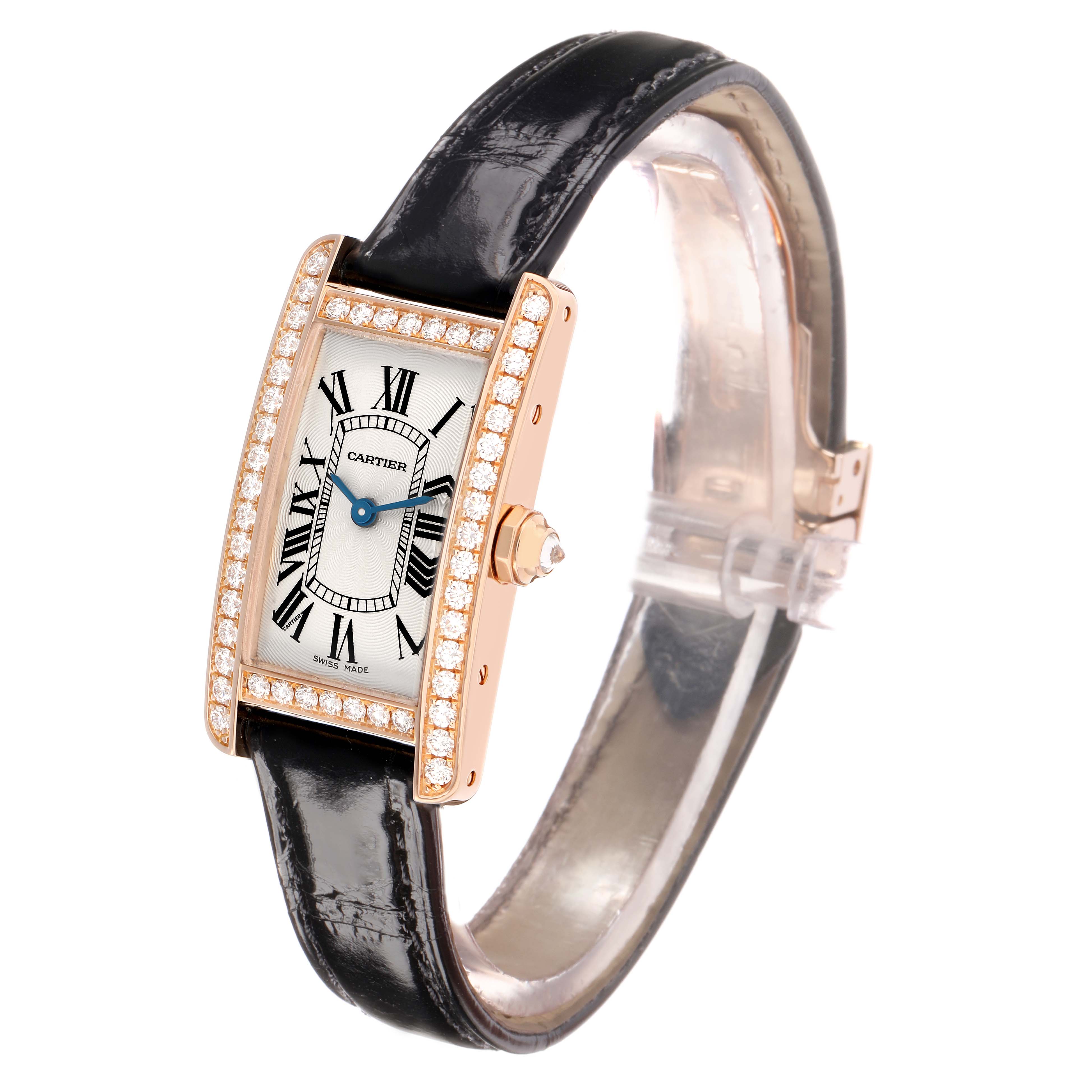 The Cartier Tank Americaine WJTA0002 Women
s Rose Gold Silver Dial watch is shown at a three-quarter angle, highlighting its diamond-encrusted bezel and black leather strap.