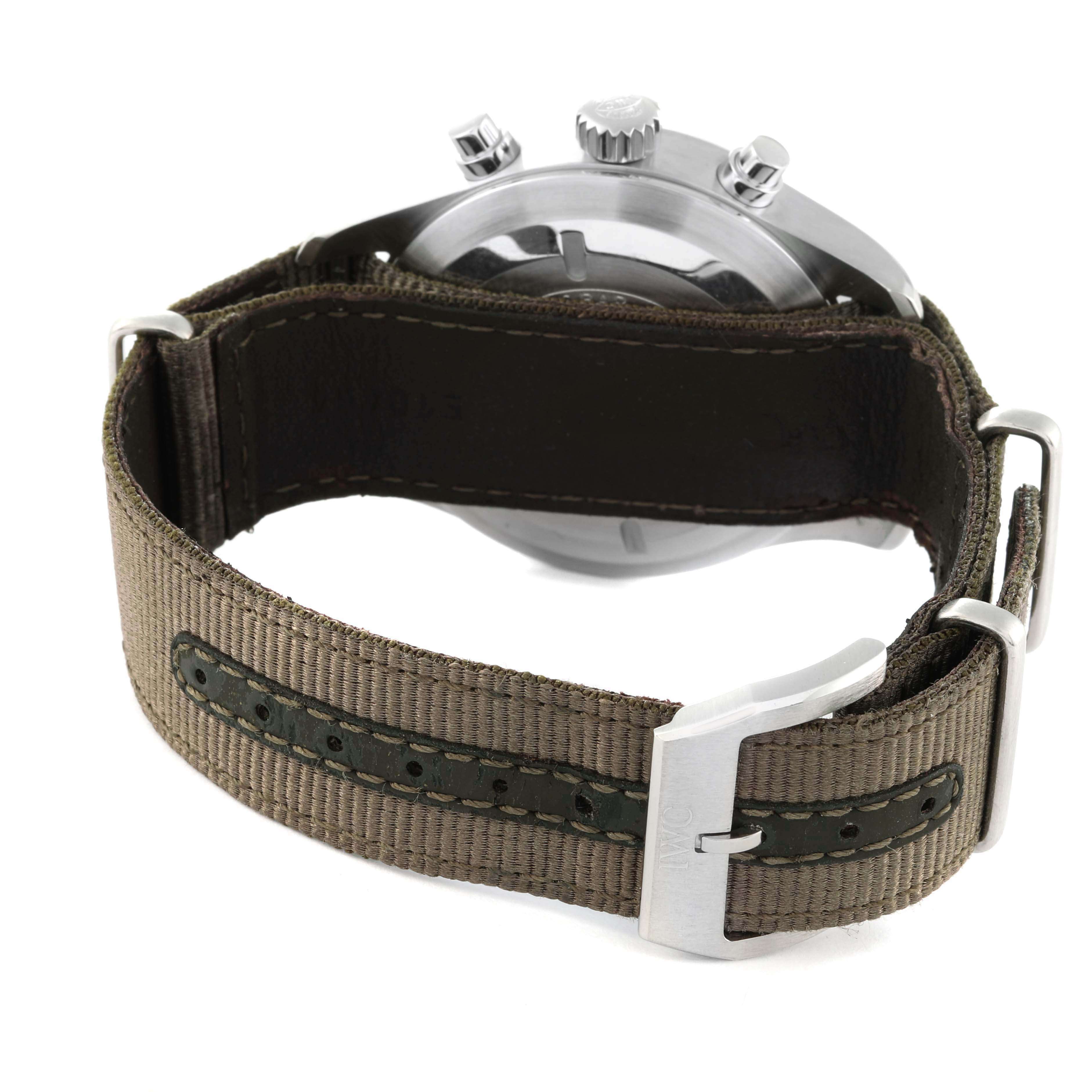 The image shows the back side and strap of an IWC Pilot IW377724 Men's Stainless Steel Black Dial IW377724 Men's Stainless Steel Black Dial model watch, featuring a green fabric strap and metal buckle.