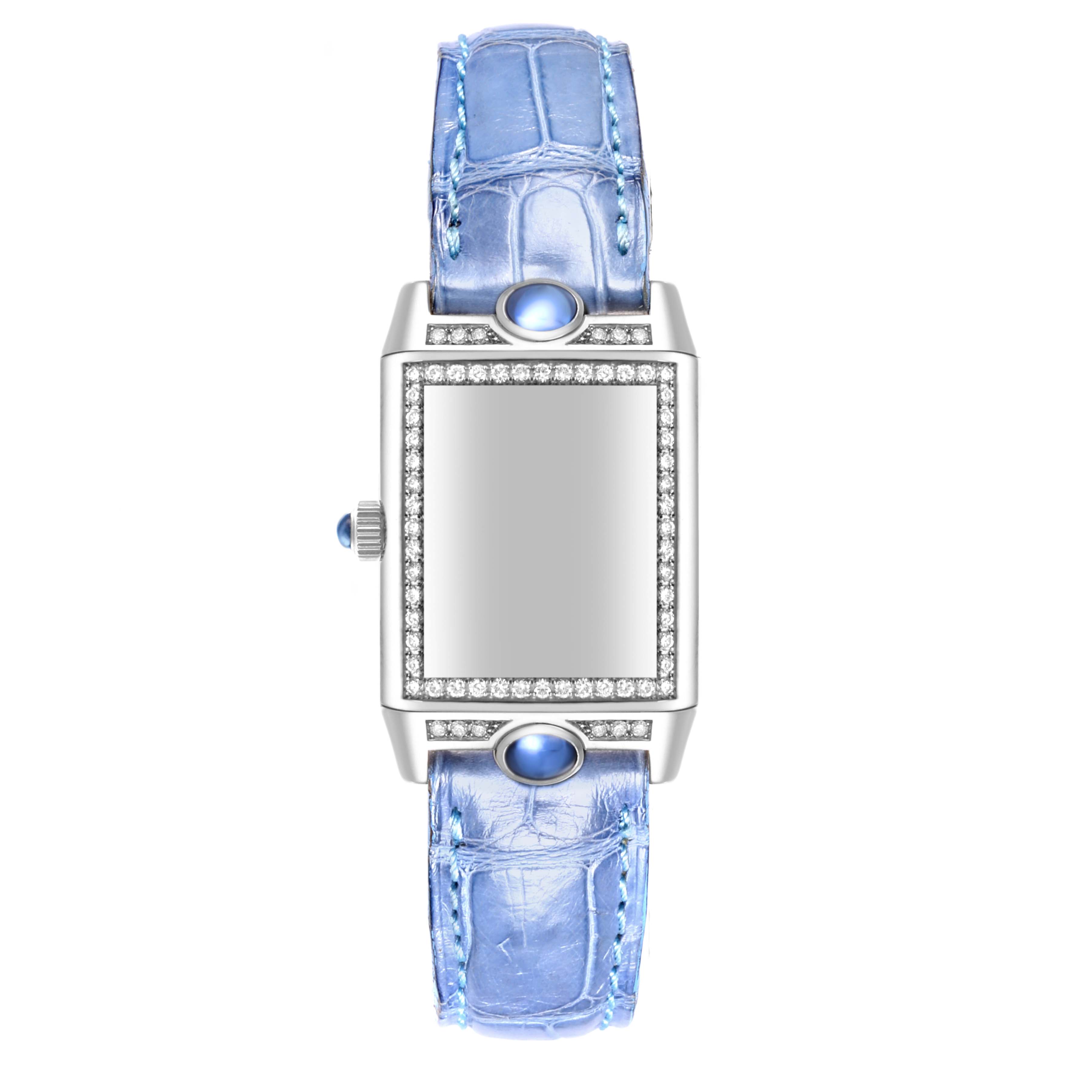 The Jaeger-LeCoultre Reverso watch is shown from a top-down angle, displaying its face, bezel, and blue leather strap.