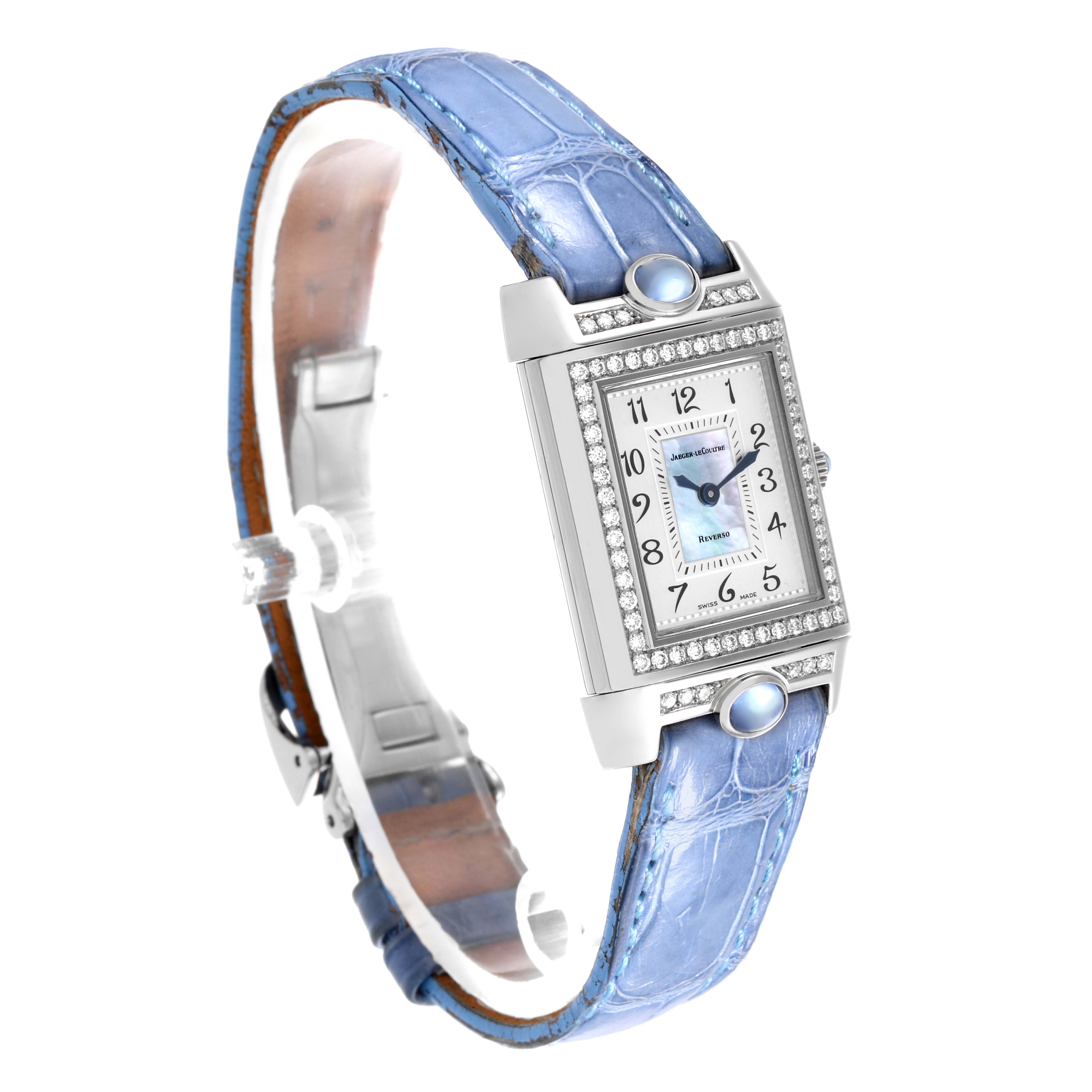The Jaeger-LeCoultre Reverso watch is shown at an angled view, highlighting the face and light blue strap.