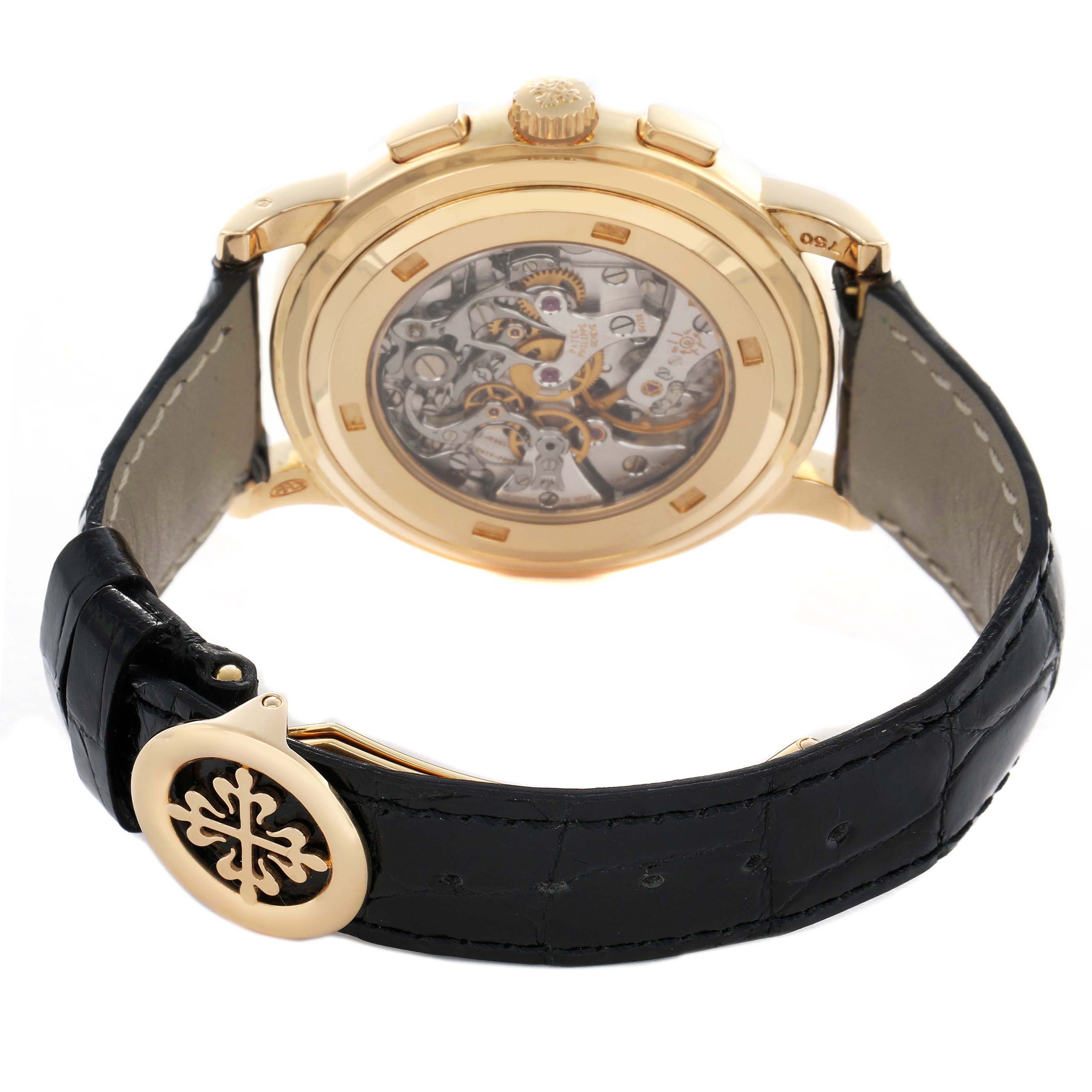 The Patek Philippe Complications 5070J-001 Men's Yellow Gold Black Dial watch is shown from a rear angle, displaying the intricate movement and part of the strap.