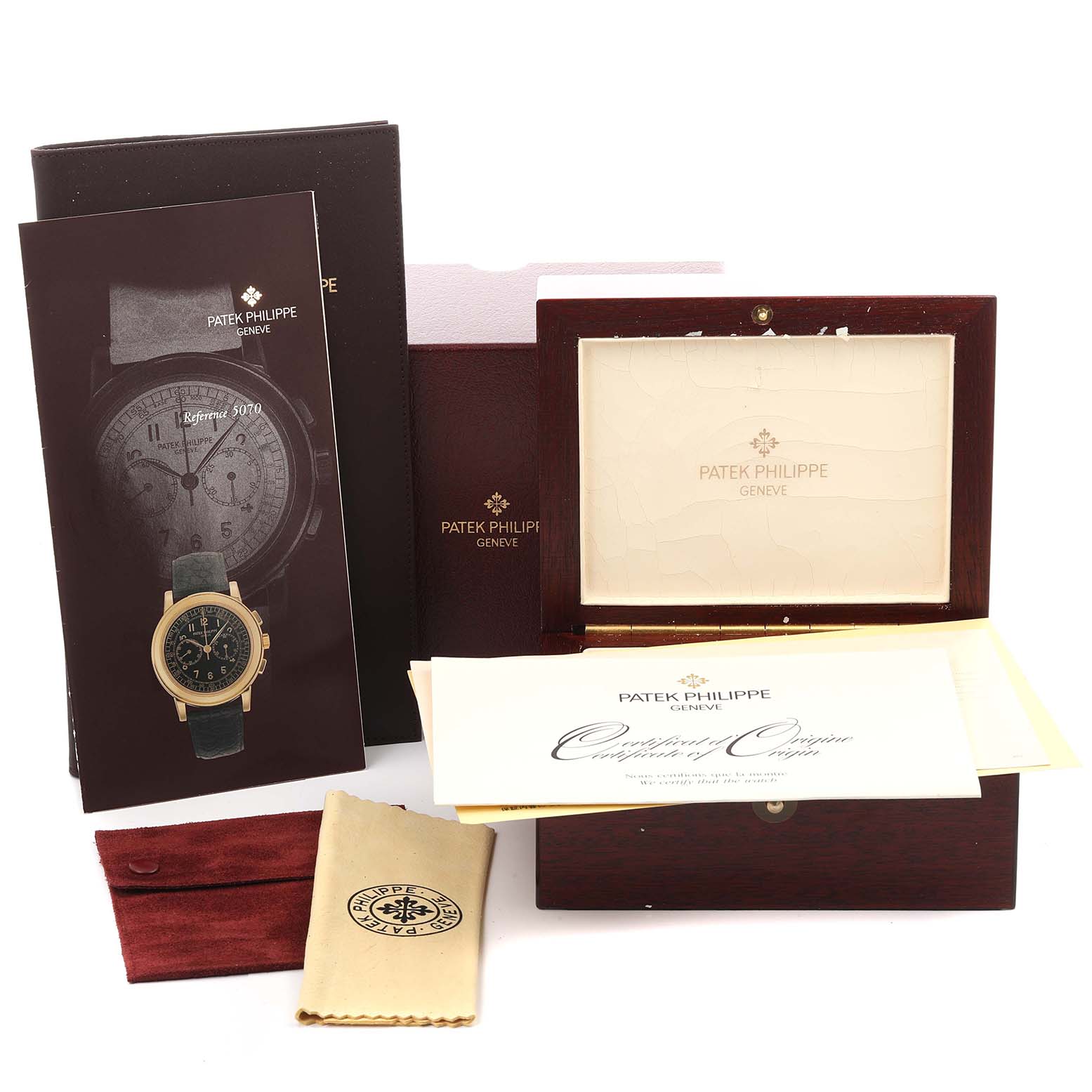 The image shows the packaging and accessories for a Patek Philippe Complications 5070J-001 Men's Yellow Gold Black Dial 5070J-001 Men's Yellow Gold Black Dial watch, including booklets and a wooden box.