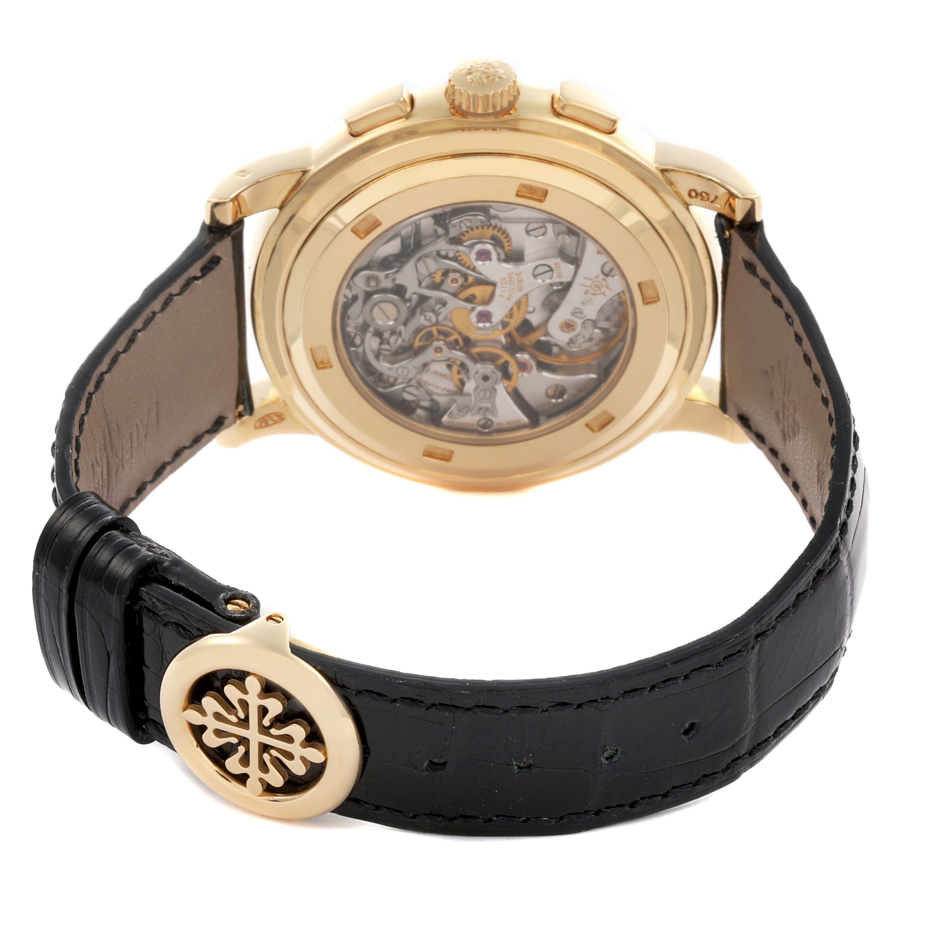 The image shows the back view of a Patek Philippe Complications 5070J-001 Men's Yellow Gold Black Dial 5070J-001 Men's Yellow Gold Black Dial watch, highlighting the movement and strap clasp.