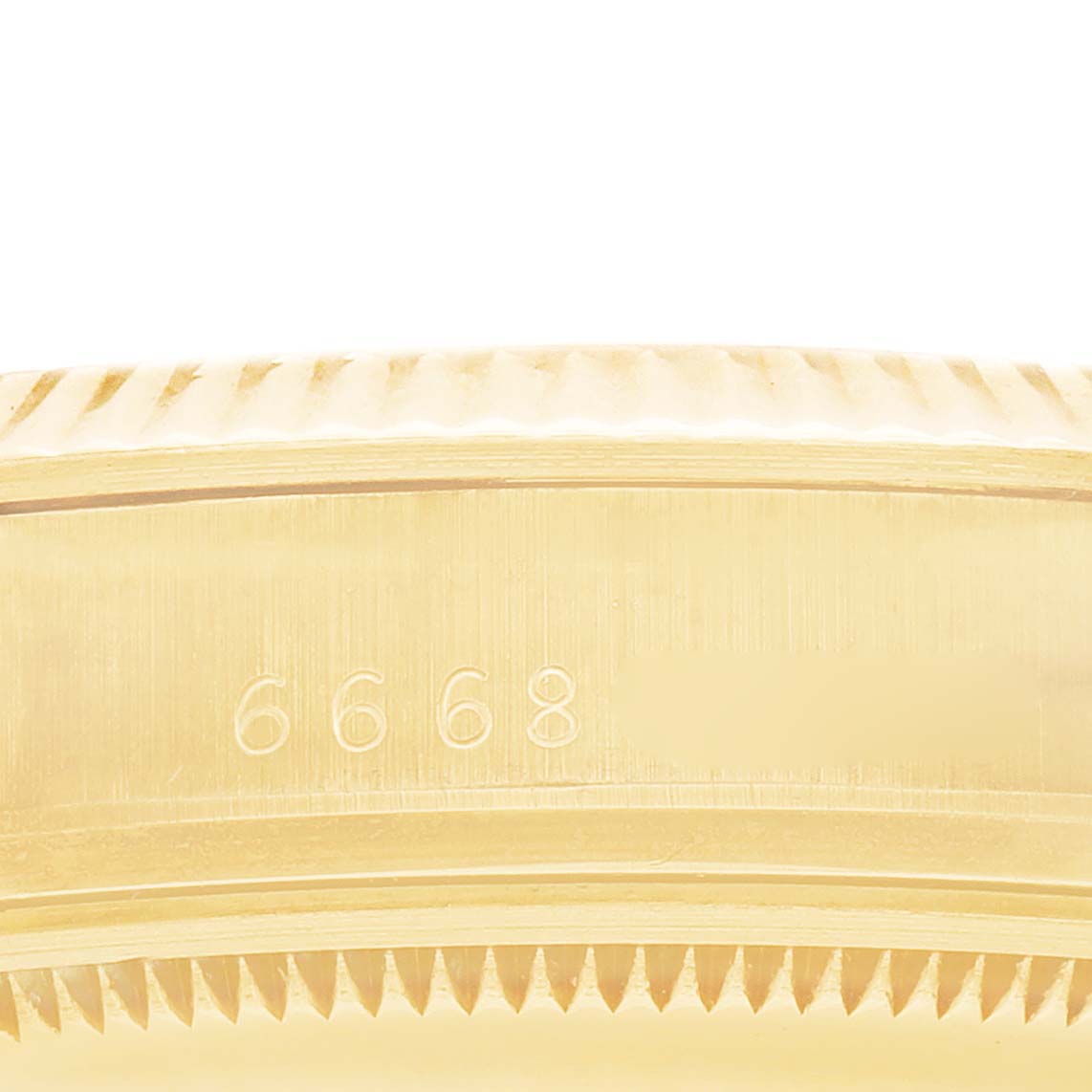 The image shows a close-up of the fluted bezel and side engraving on a Rolex Date 15037 Men
s Yellow Gold Champagne Dial model watch.
