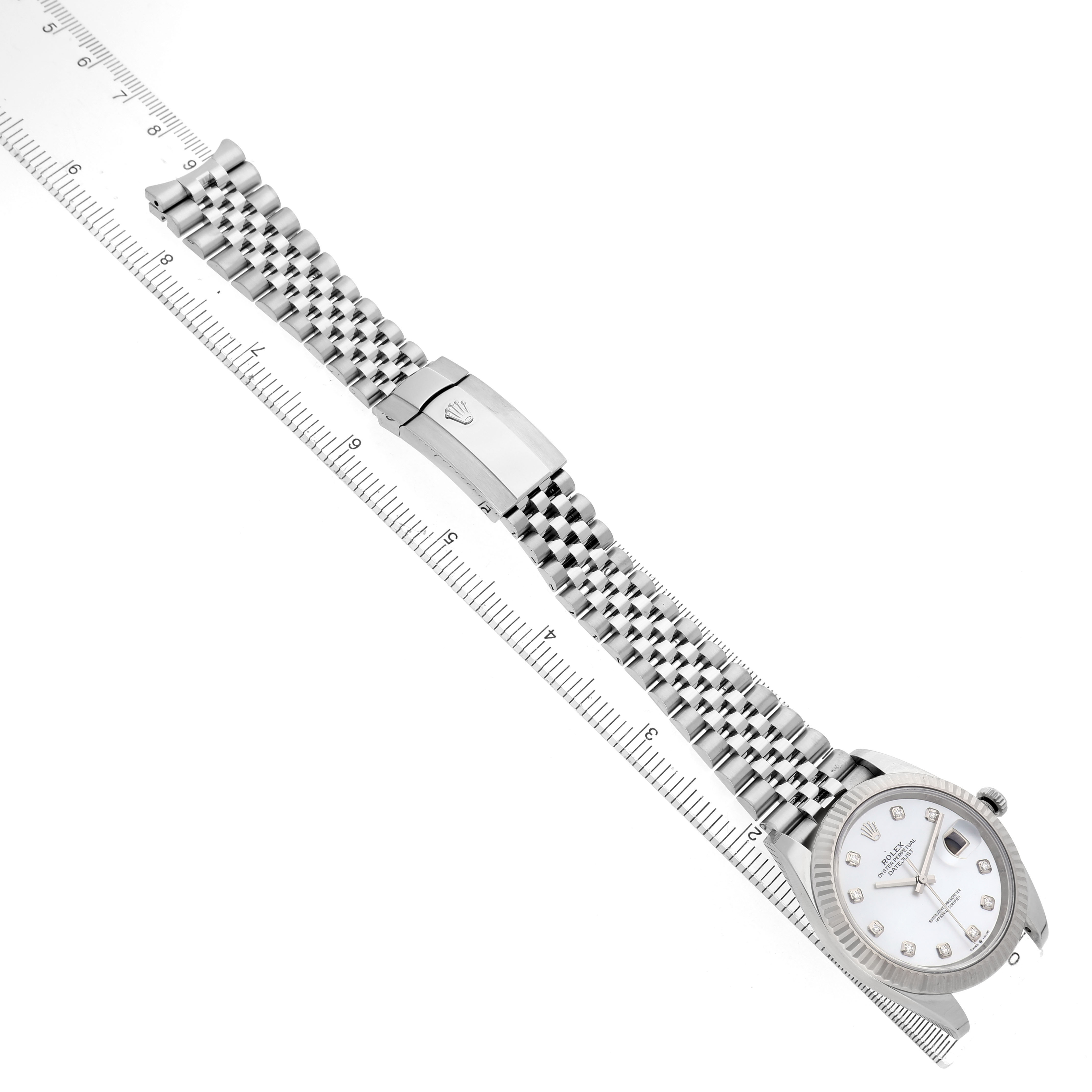 The Rolex Datejust 41 126334 Men's Stainless Steel Mother of Pearl Dial is shown from a diagonal top view, displaying the face, bezel, bracelet, and clasp aligned with a ruler.