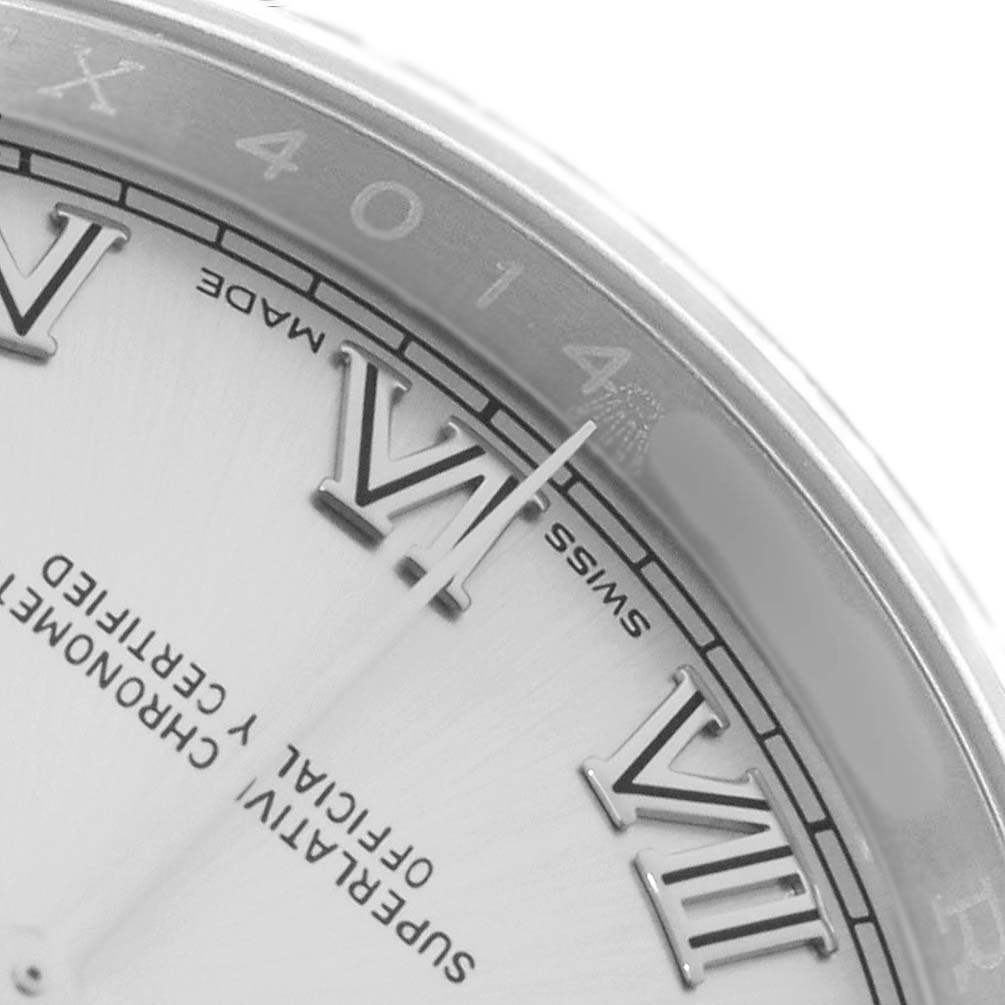 The image shows a close-up of the Rolex Datejust 116234 Men
s Stainless Steel Silver Dial dial featuring Roman numerals and part of the rehaut with engravings.