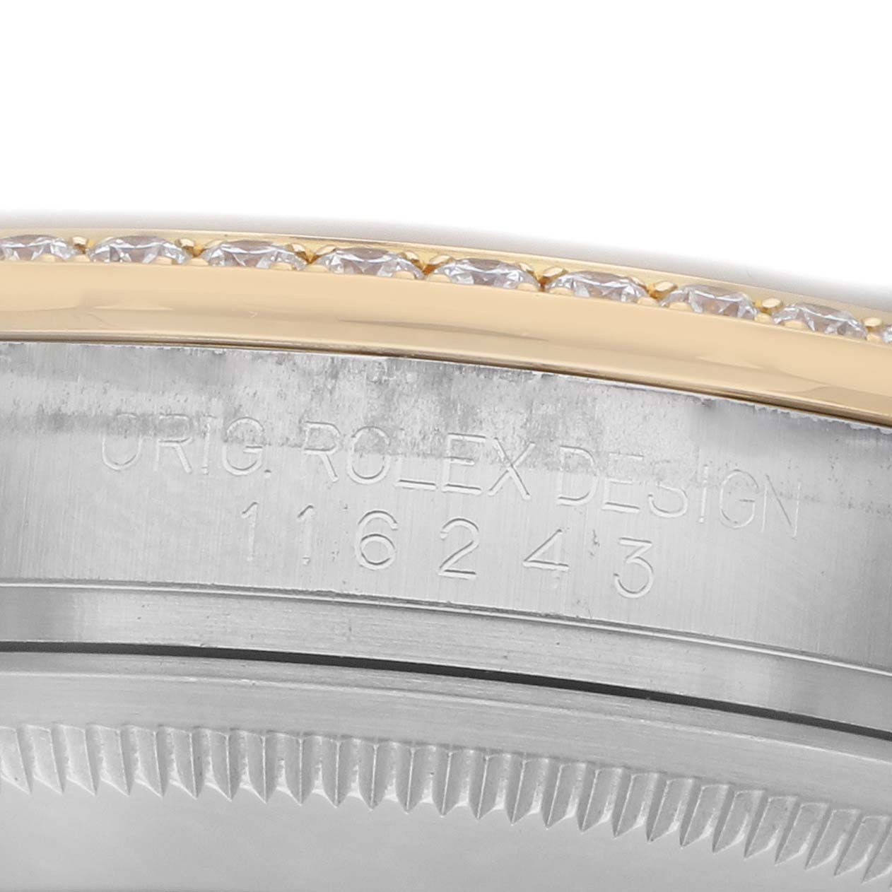 The image shows a close-up of the bezel and case side of a Rolex Datejust 116243 Men
s Steel and Gold (two tone) Silver Dial watch, featuring engravings and a jeweled bezel.