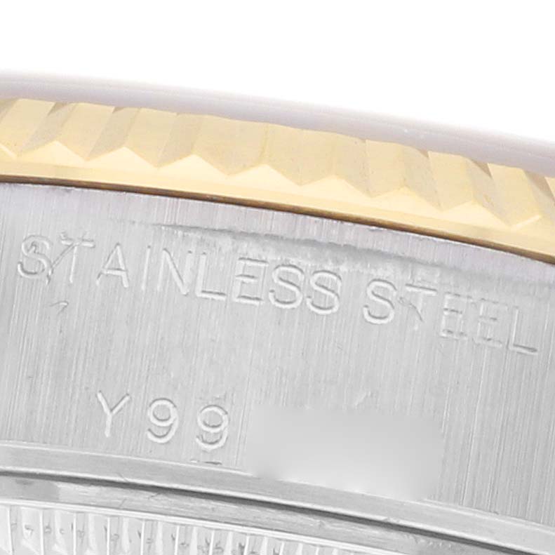 The image shows a close-up of the Rolex Datejust 79173 Women
s Steel and Gold (two tone) Champagne Dial case
s side, highlighting the stainless steel and part of the fluted bezel.