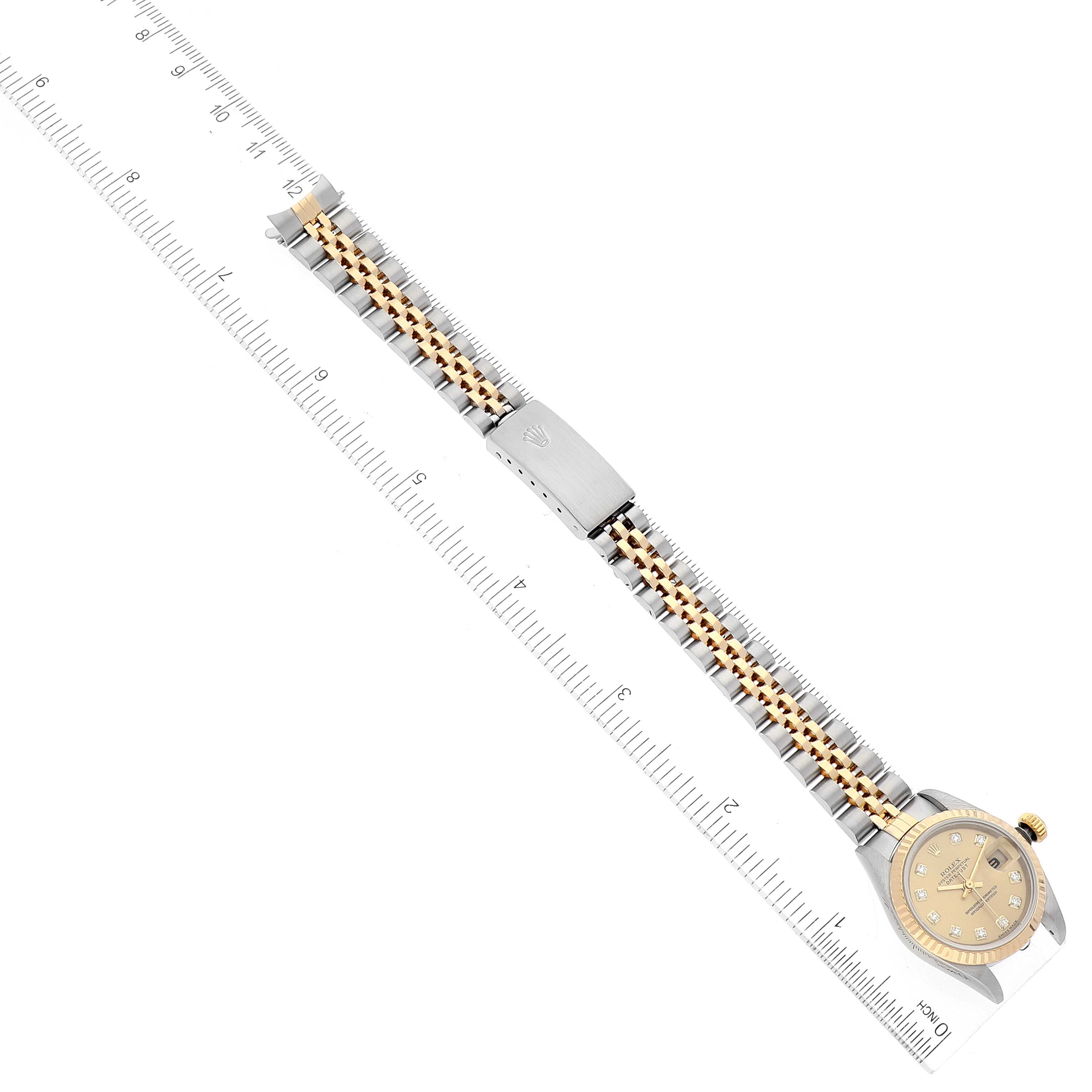 The image shows an overhead view of a Rolex Datejust 79173 Women's Steel and Gold (two tone) Champagne Dial 79173 Women's Steel and Gold (two tone) Champagne Dial watch with its bracelet extended and a ruler for measurement.