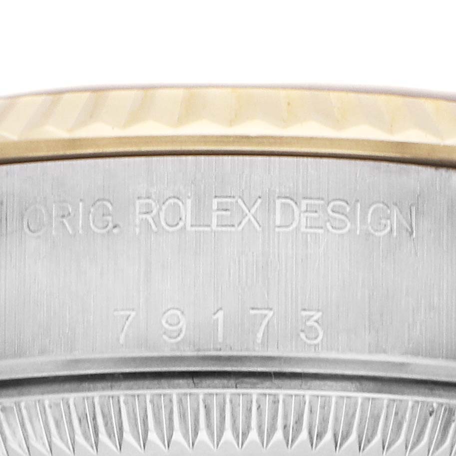 The image shows a close-up of the side of the Rolex Datejust 79173 Women
s Steel and Gold (two tone) Champagne Dial bezel and case, featuring the model number engraving.