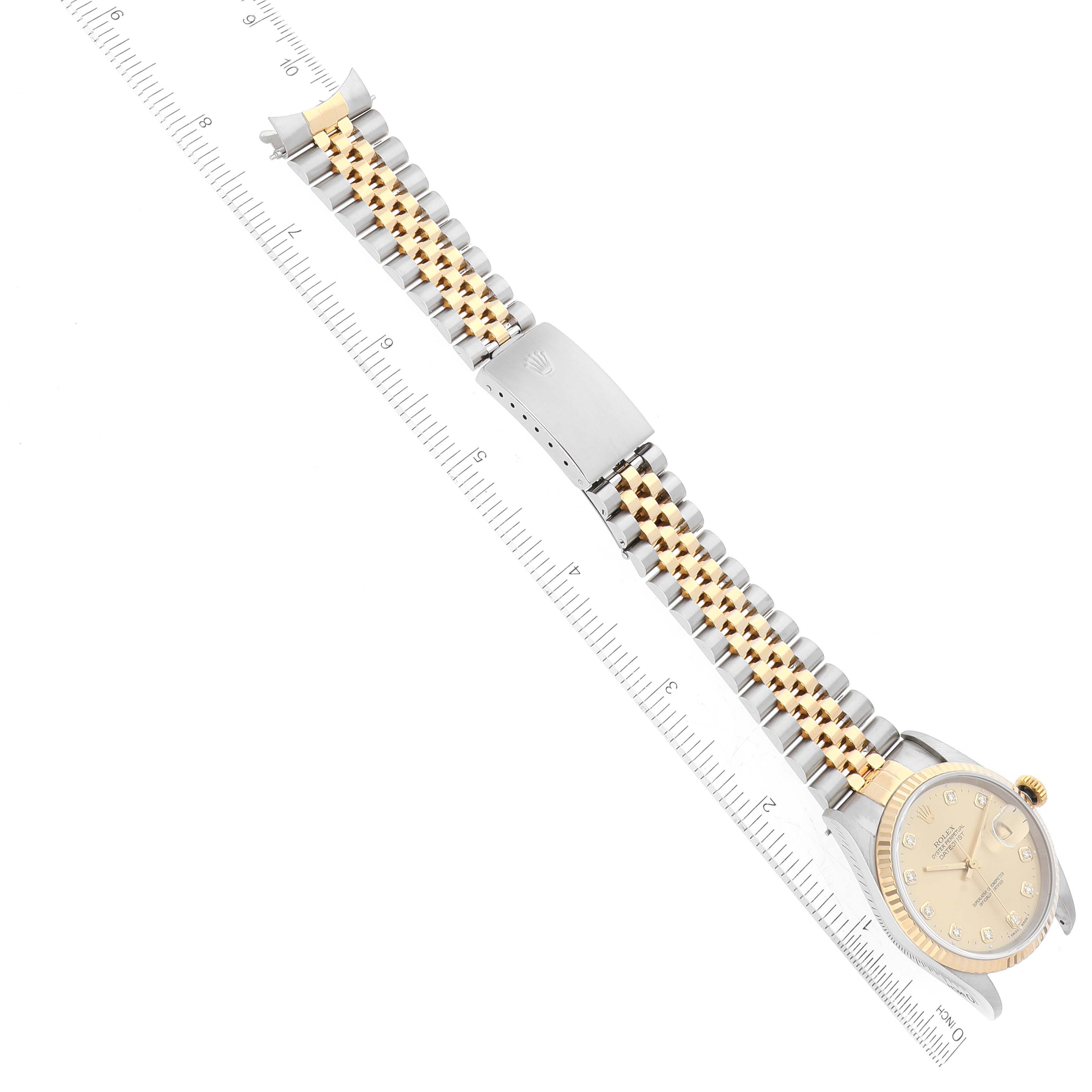 The image shows a Rolex Datejust 16233 Men's Steel and Gold (two tone) Champagne Dial 16233 Men's Steel and Gold (two tone) Champagne Dial watch laying flat, highlighting its two-tone bracelet and face, alongside a measuring ruler.