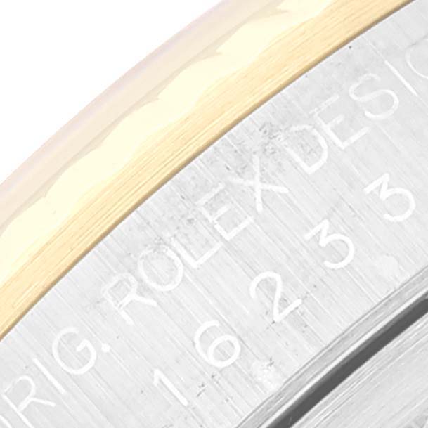 This close-up angle shows a partial view of the bezel and outer dial, highlighting the engraving on the Rolex Datejust 16233 Men's Steel and Gold (two tone) Champagne Dial 16233 Men's Steel and Gold (two tone) Champagne Dial watch.