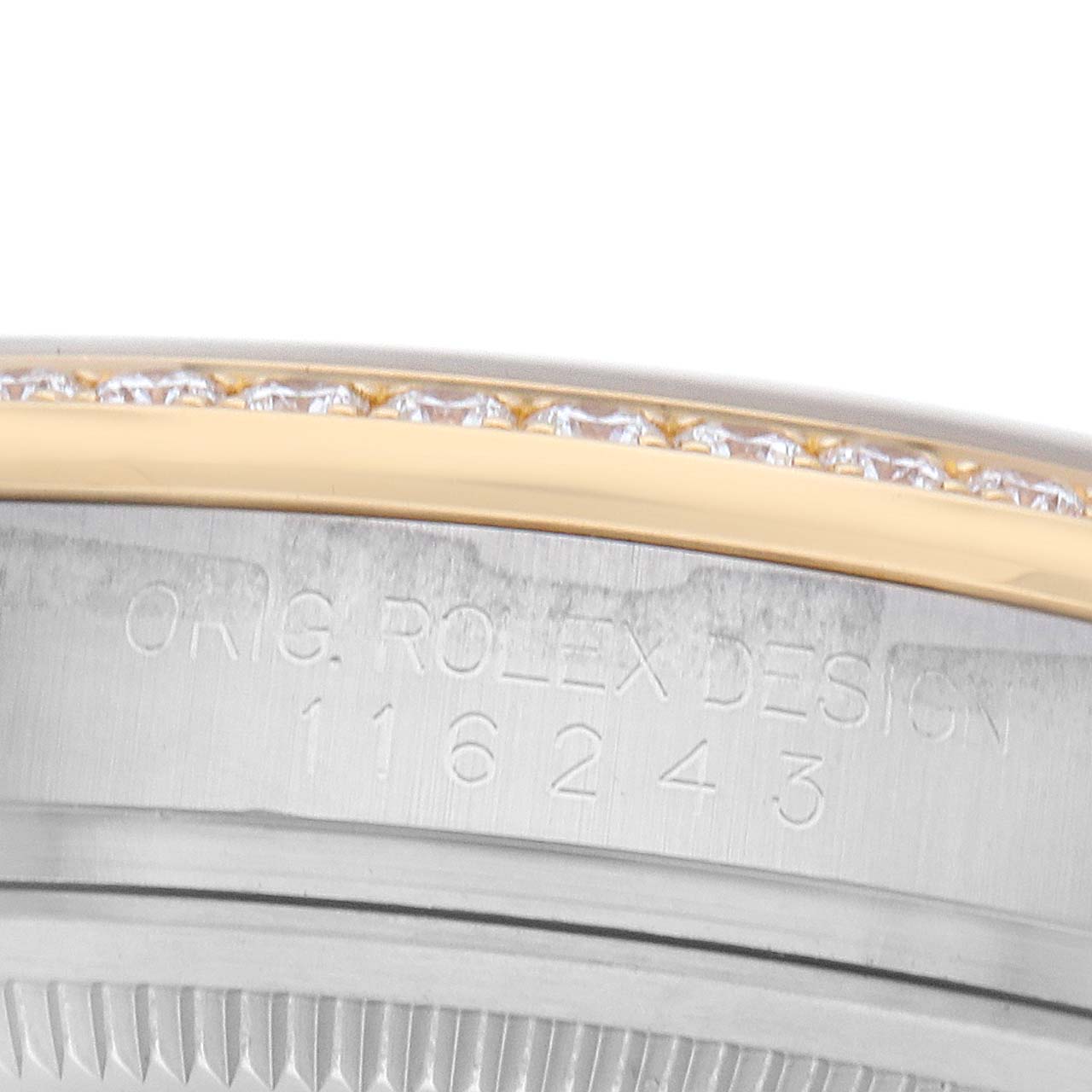 The image shows a close-up of a Rolex Datejust 116243 Men
s Steel and Gold (two tone) Silver Dial
s bezel edge with diamond accents and engraved part of the case.