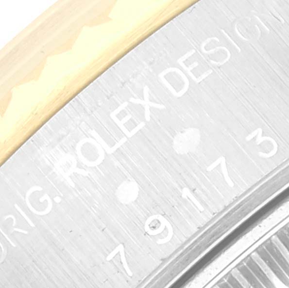 This image shows a close-up of the outer casing with engraved text on a Rolex Datejust 79173 Women's Steel and Gold (two tone) White Dial 79173 Women's Steel and Gold (two tone) White Dial watch.