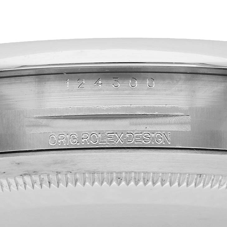 The image shows a close-up of the Rolex Oyster Perpetual 124300 Men
s Stainless Steel Silver Dial
s case edge with engraved model number and design inscription.
