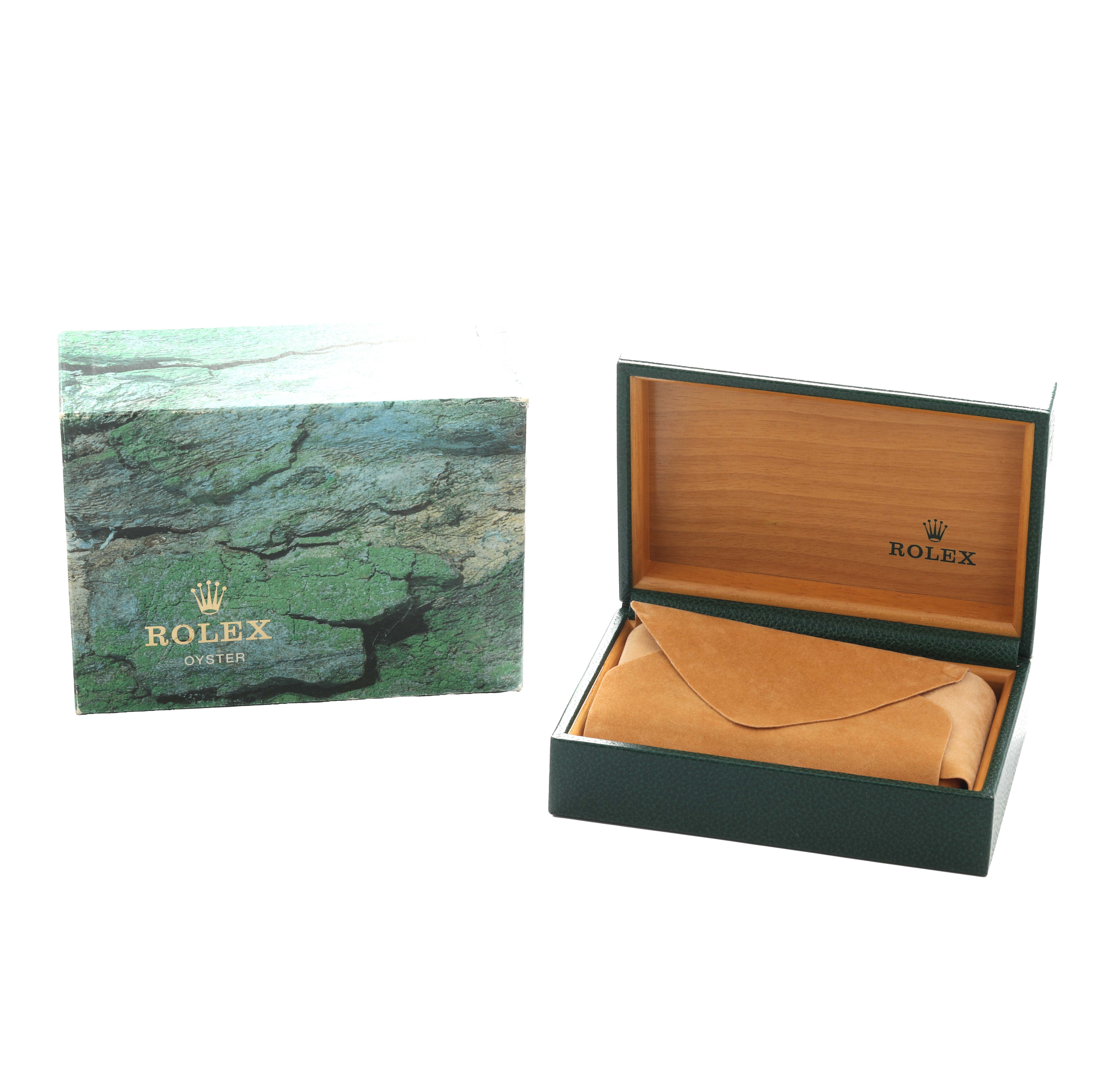 The image shows the packaging and box for the Rolex Oyster Perpetual 14203 Men
s Steel and Gold (two tone) Champagne Dial, with a green outer box and an open inner box with a cushion.