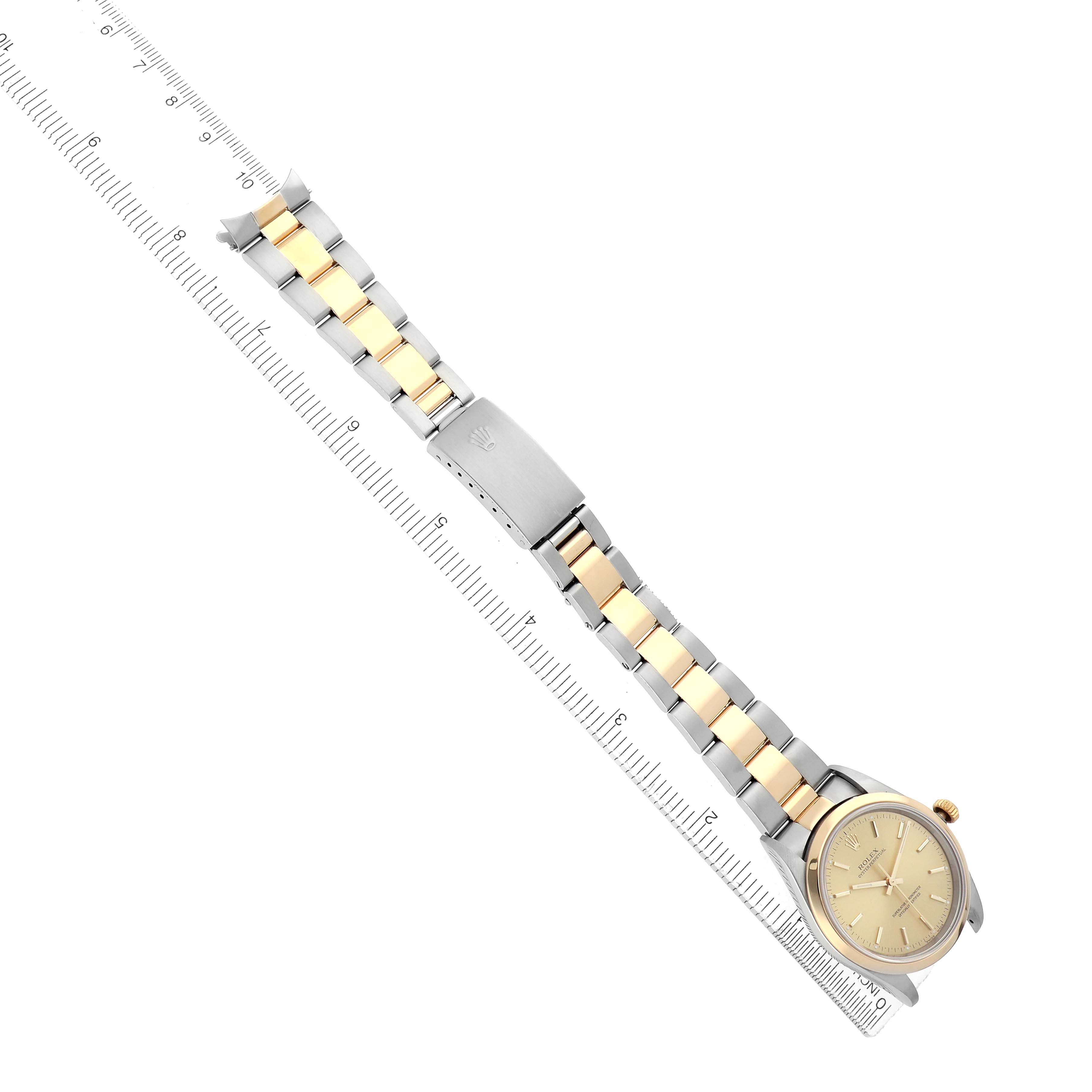 The Rolex Oyster Perpetual 14203 Men
s Steel and Gold (two tone) Champagne Dial watch is shown from an overhead angle, highlighting the bracelet and clasp along with the dial.