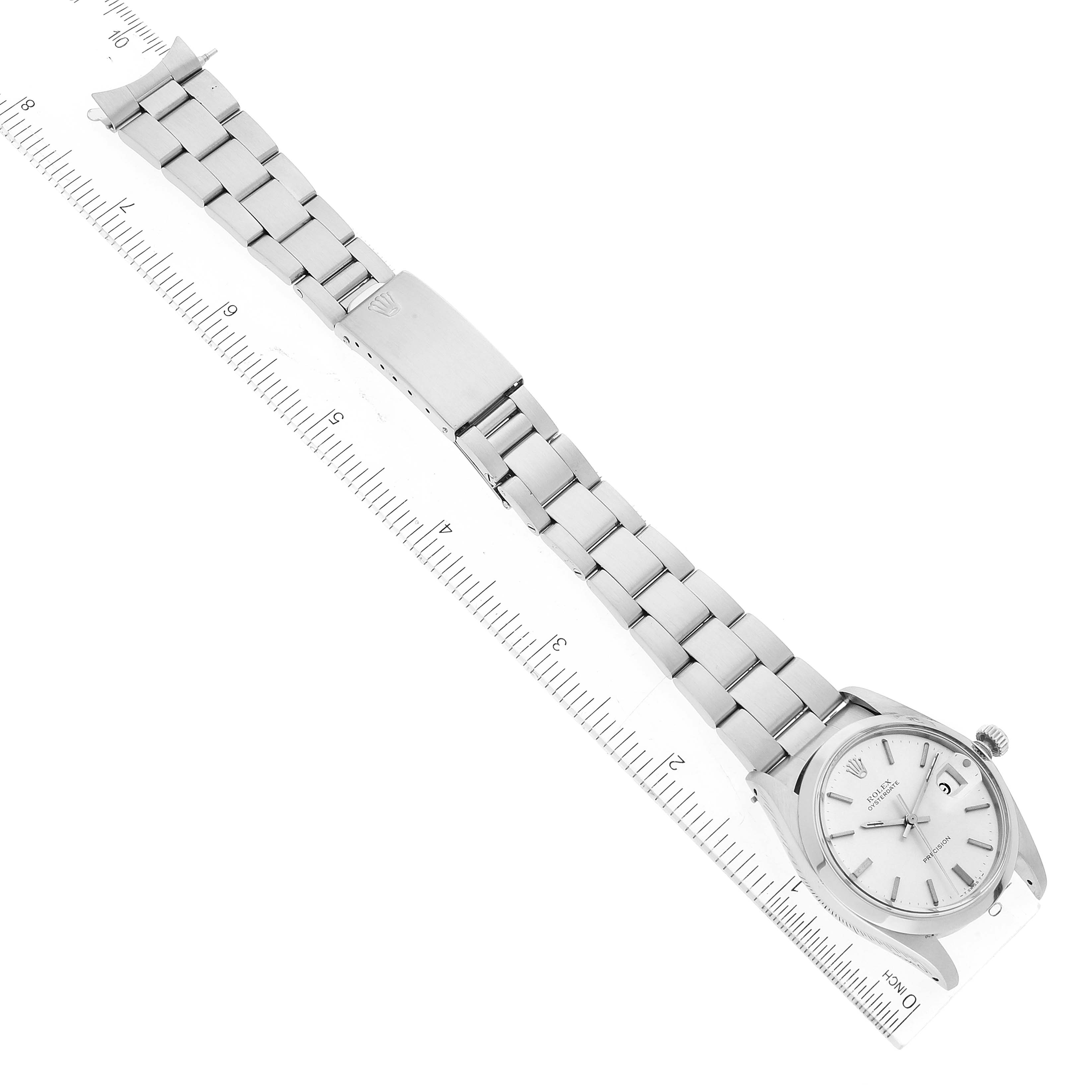 This image shows a Rolex Vintage Collection 6694 Men
s Stainless Steel Silver Dial 6694 Men
s Stainless Steel Silver Dial watch laid flat with an attached ruler, highlighting the bracelet and case.