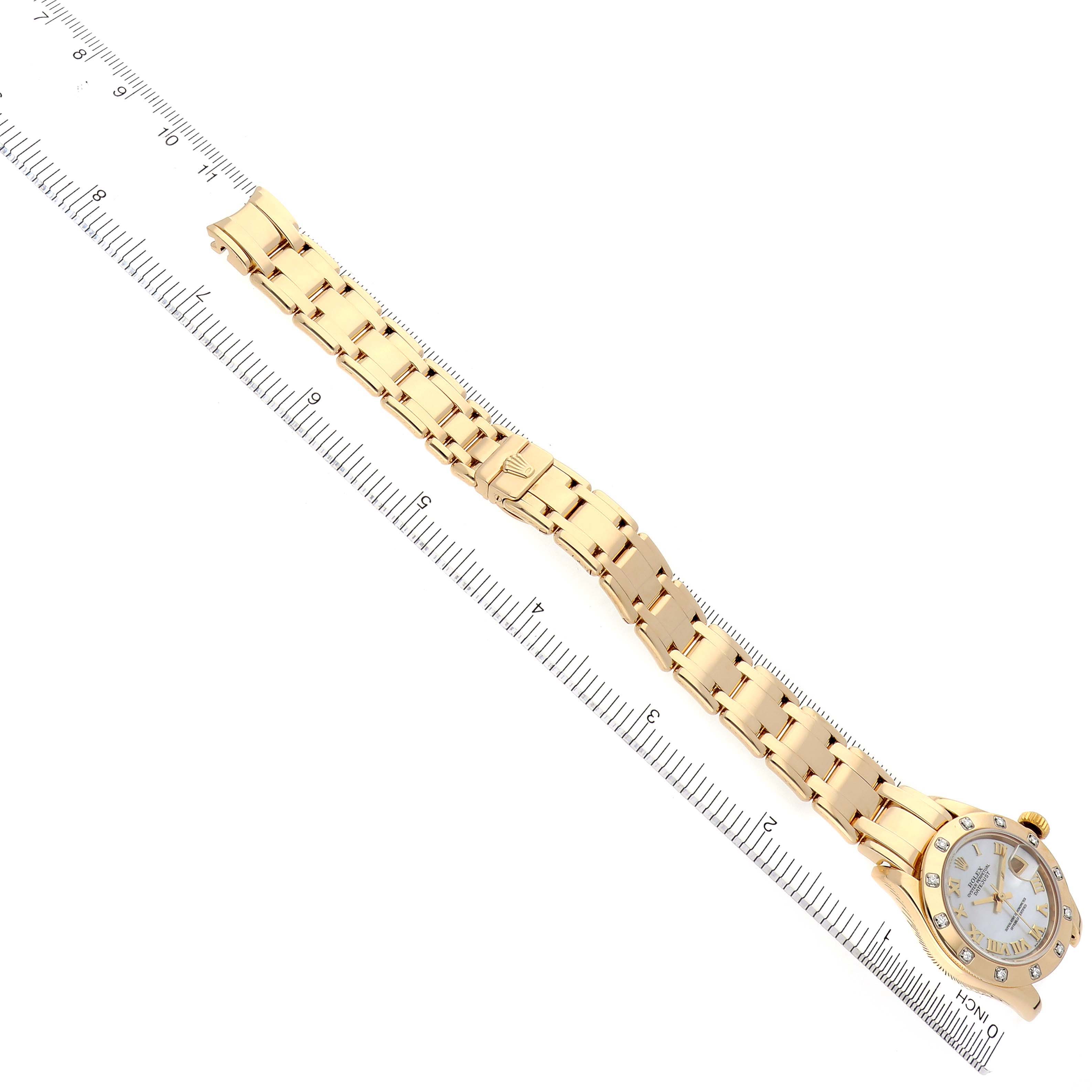 The Rolex Pearlmaster 80318 Women's Yellow Gold Mother of Pearl Dial 80318 Women's Yellow Gold Mother of Pearl Dial is shown from a top-down angle, displaying the entire watch and its bracelet against a measuring scale.