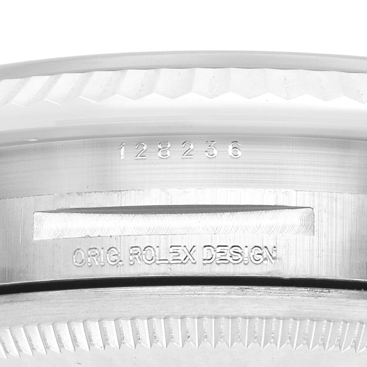 This image shows a close-up of the side of the Rolex President 128236 Men
s Platinum Blue Dial watch case with engraved details and fluted bezel.
