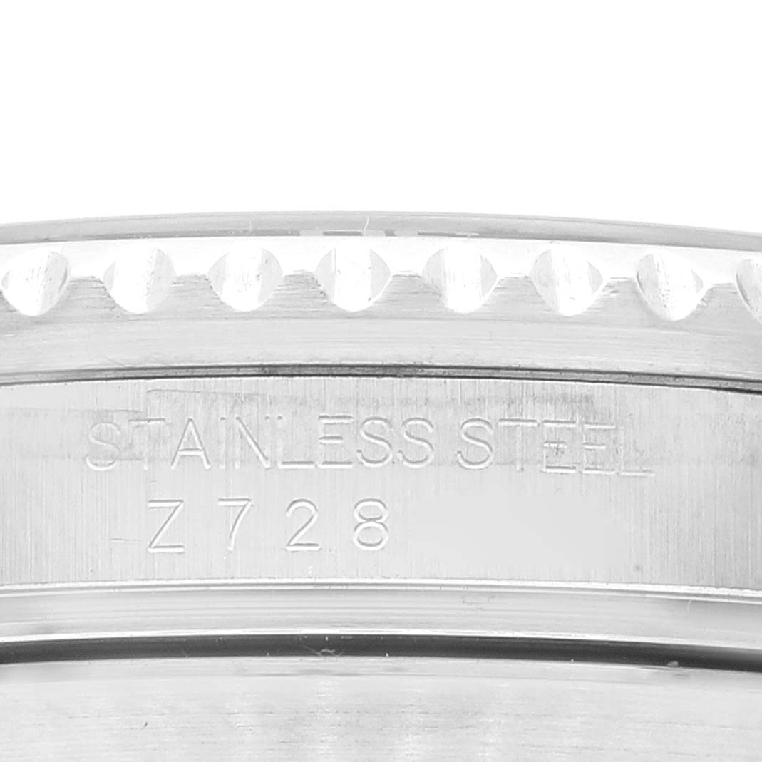 The image shows the side engraving and partially the bezel of a Rolex Submariner 16610LV Men's Stainless Steel Black Dial 16610LV Men's Stainless Steel Black Dial watch, indicating its stainless steel build.
