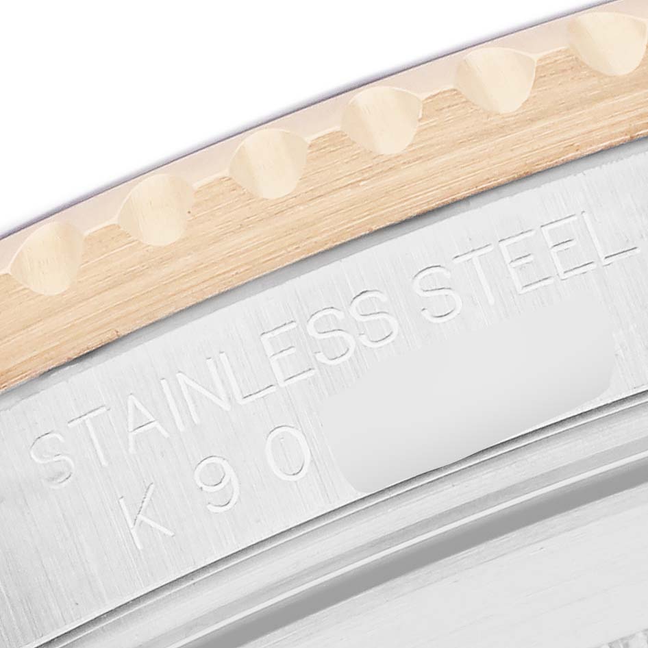 The image shows a close-up of the Rolex Submariner 16613 Men
s Steel and Gold (two tone) Black Dial
s case, highlighting the stainless steel bezel and engraved markings.