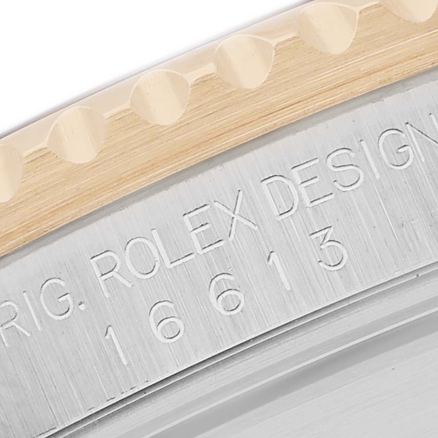 This image shows a close-up of the Rolex Submariner 16613 Men
s Steel and Gold (two tone) Black Dial
s bezel and case side, highlighting the engraved model number.