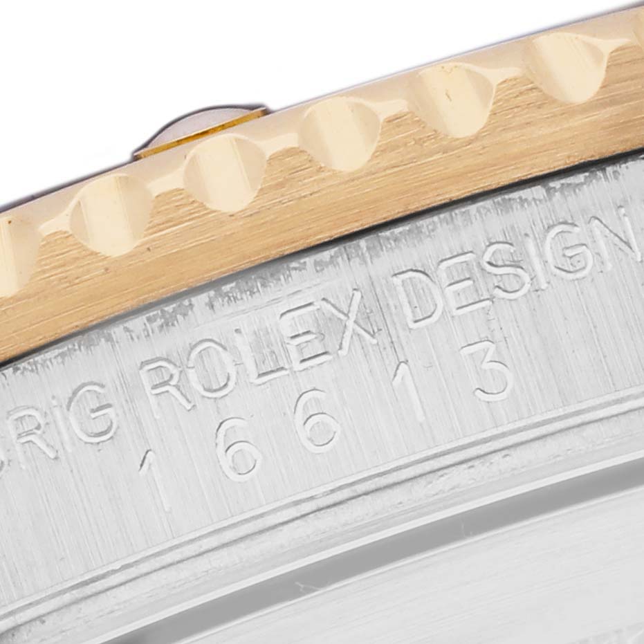 The image shows a close-up of the bezel and part of the case with engravings of a Rolex Submariner 16613 Men
s Steel and Gold (two tone) Blue Dial watch model.