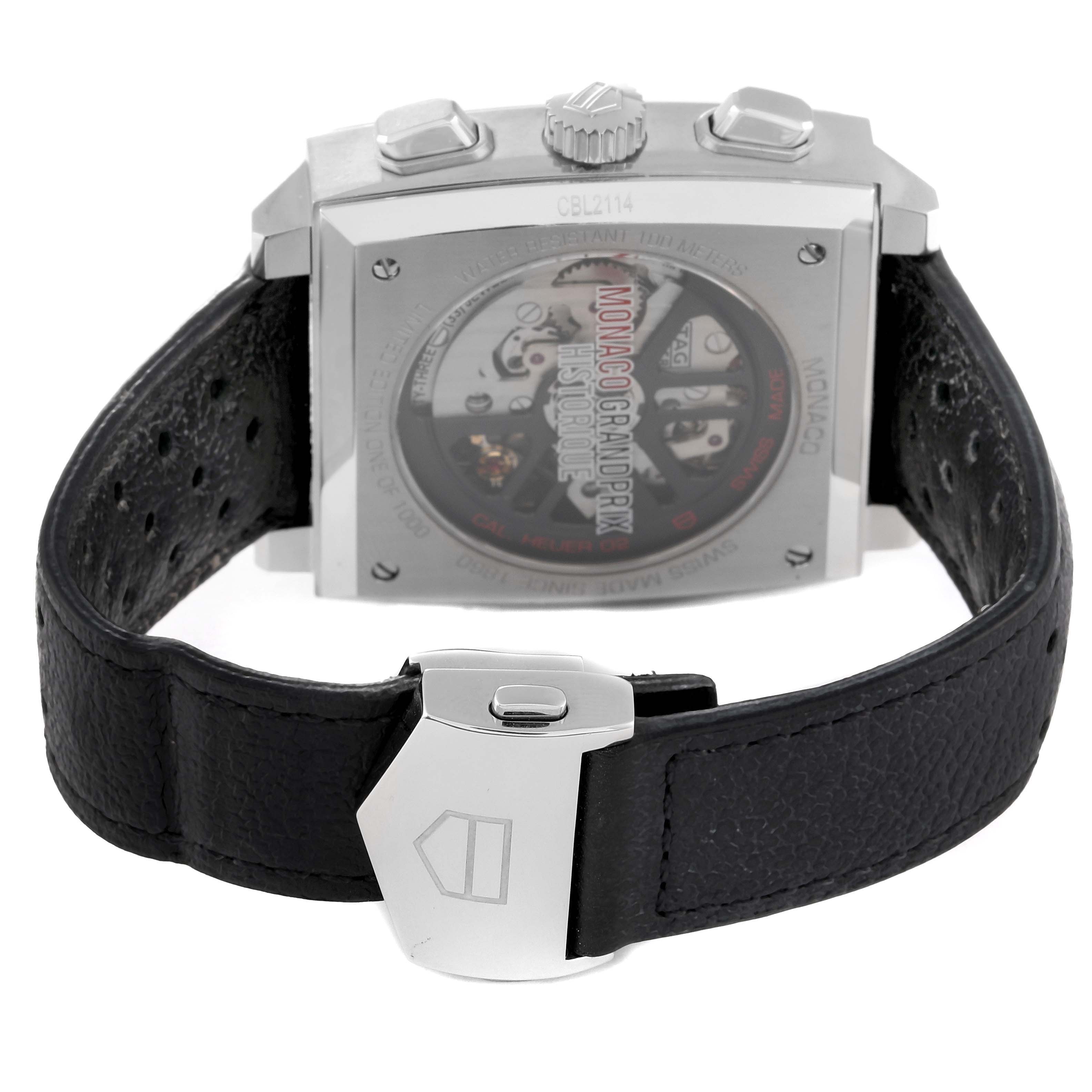 The image shows the back view of a Tag Heuer Monaco CBL2114.FC6486 Men's Stainless Steel Red Dial CBL2114.FC6486 Men's Stainless Steel Red Dial watch featuring its mechanism and a black leather strap with a clasp.