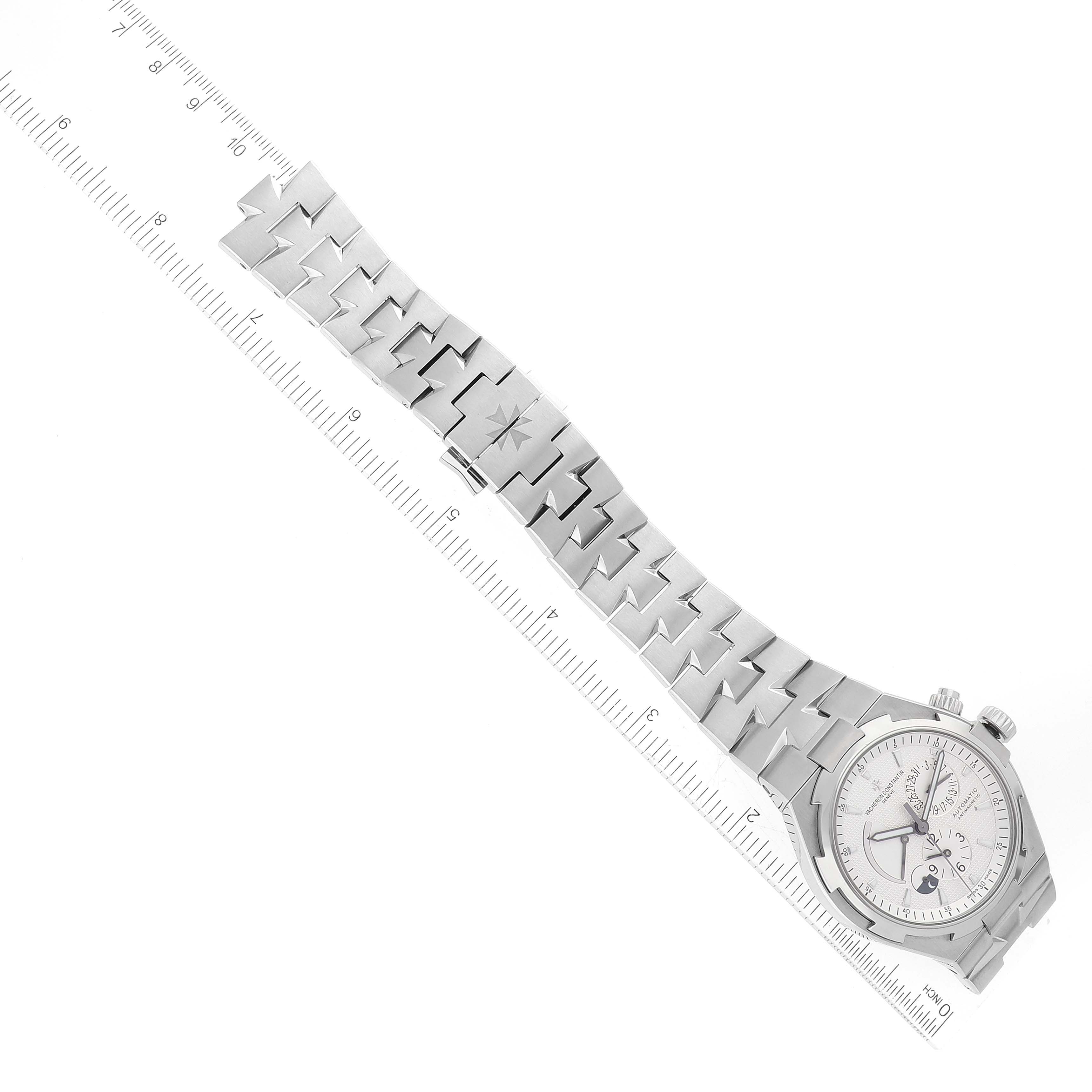 The image shows a Vacheron Constantin Overseas 47450/B01A-9226 Men
s Stainless Steel Silver Dial 47450/B01A-9226 Men
s Stainless Steel Silver Dial watch in a flat view, displaying its dial and metal bracelet alongside a ruler for scale.