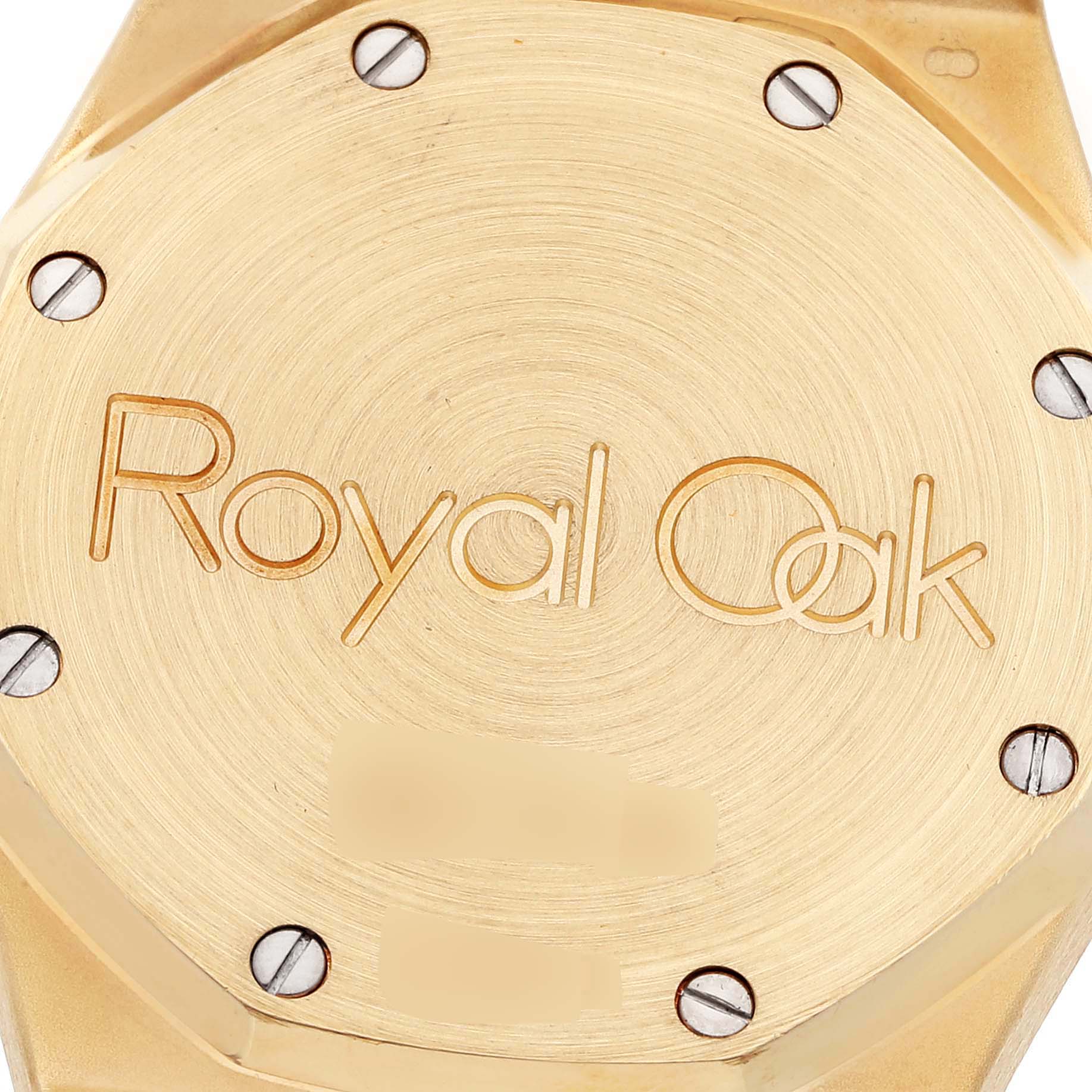 The image shows the case back of an Audemars Piguet Royal Oak 25594BA.OO.0477BA.01 Men's Yellow Gold Champagne Dial 25594BA.OO.0477BA.01 Men's Yellow Gold Champagne Dial watch, featuring engraved text and screws.