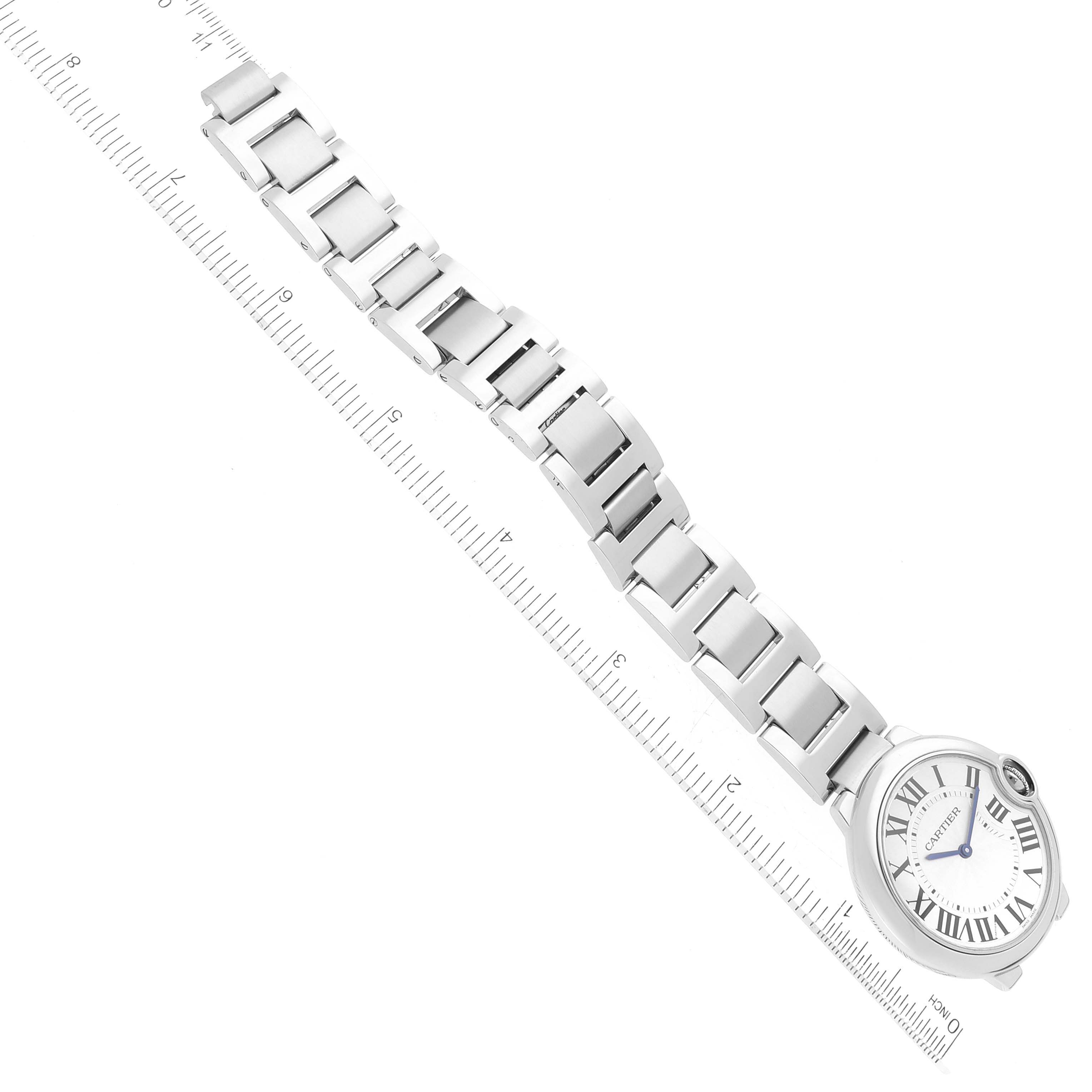 The image shows a Ballon Bleu de Cartier watch with a metal strap, positioned alongside a ruler for scale.