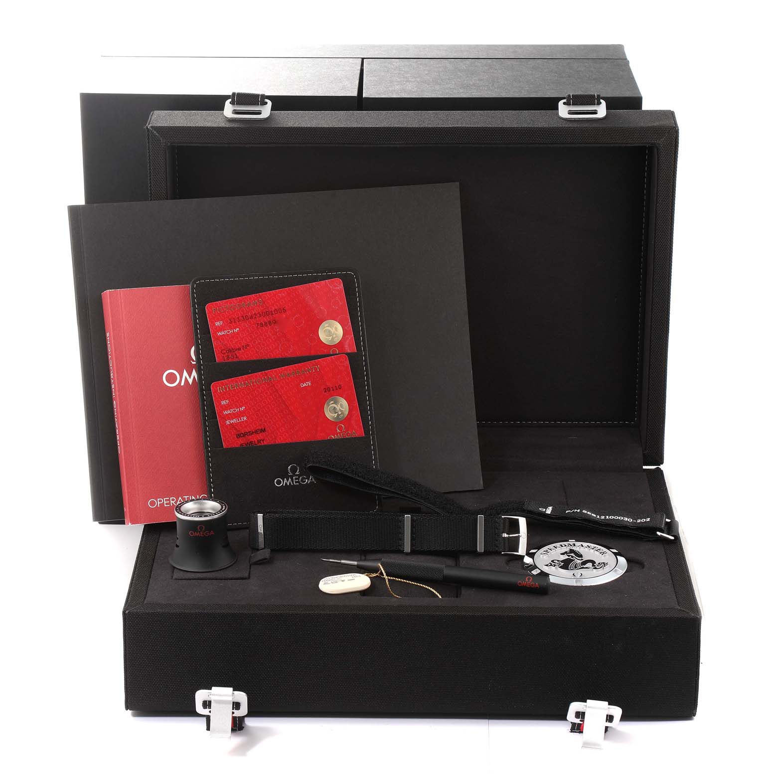 This image shows accessories for an Omega Speedmaster 311.30.42.30.01.005 Men's Stainless Steel Black Dial 311.30.42.30.01.005 Men's Stainless Steel Black Dial watch, including documentation, straps, tools, and a loupe, taken from a front angle.
