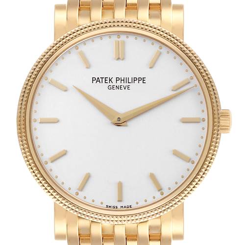 The Patek Philippe Calatrava watch is shown from the front, highlighting its gold case, white dial, and gold bracelet.