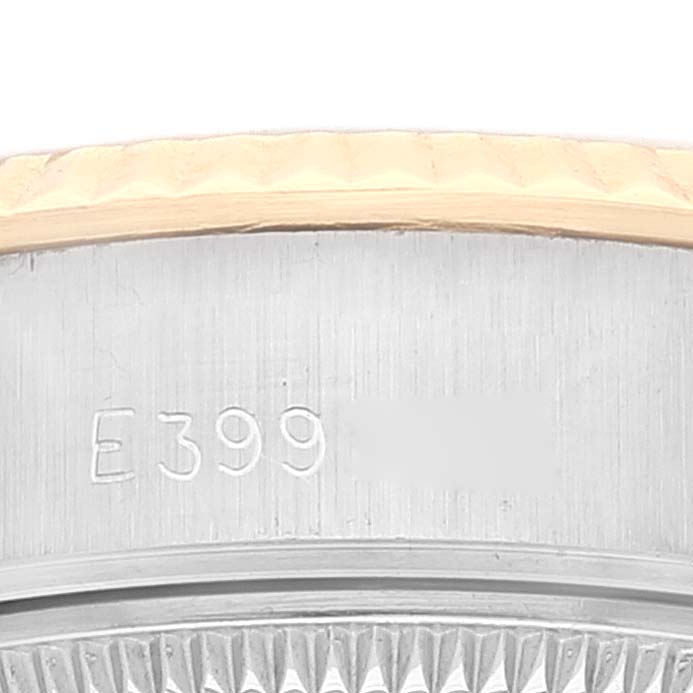 This image shows a close-up angle of a Rolex Datejust 69173 Women's Steel and Gold (two tone) Champagne Dial 69173 Women's Steel and Gold (two tone) Champagne Dial model's case with part of the fluted bezel and serial number visible.
