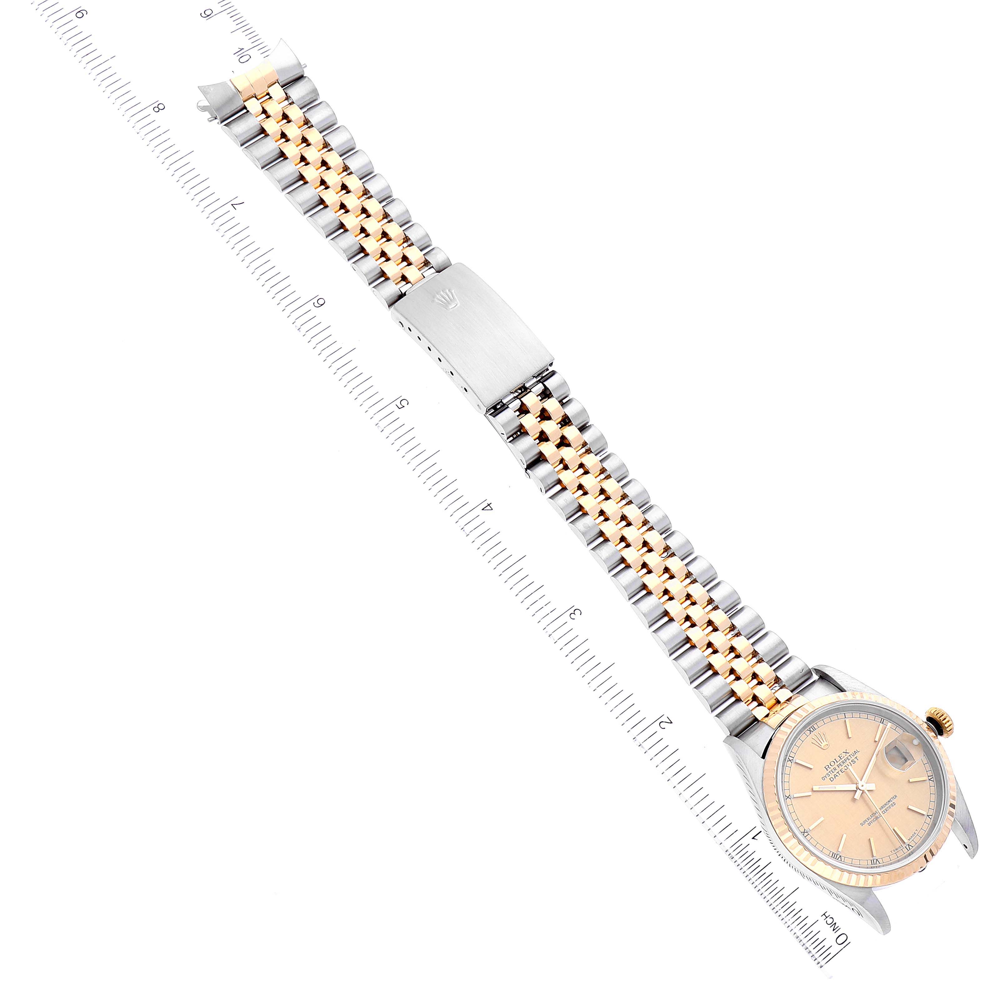 The image shows a Rolex Datejust 16233 Men's Steel and Gold (two tone) Champagne Dial 16233 Men's Steel and Gold (two tone) Champagne Dial watch from an overhead angle, highlighting the dial, bracelet, and clasp, alongside a ruler for scale.