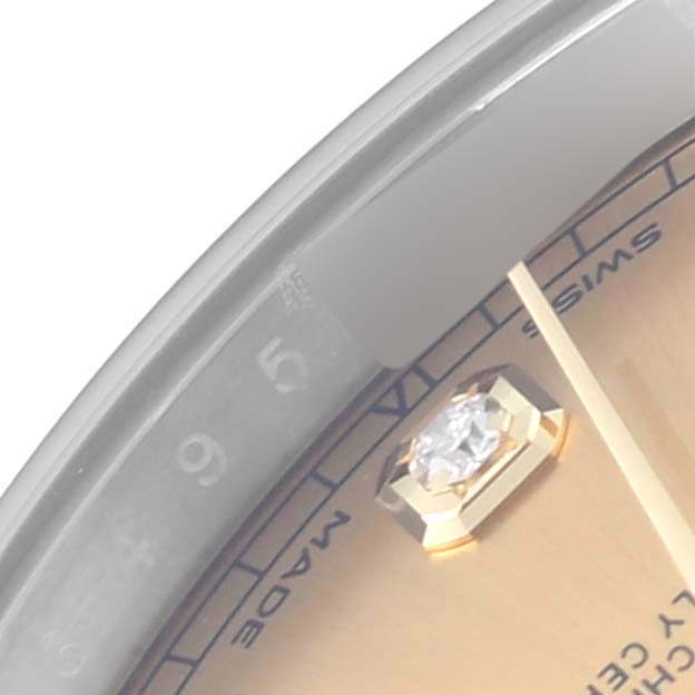The image shows a close-up of the Rolex Datejust 41 126303 Men's Steel and Gold (two tone) Champagne Dial 126303 Men's Steel and Gold (two tone) Champagne Dial's dial, focusing on a diamond hour marker and part of the bezel.