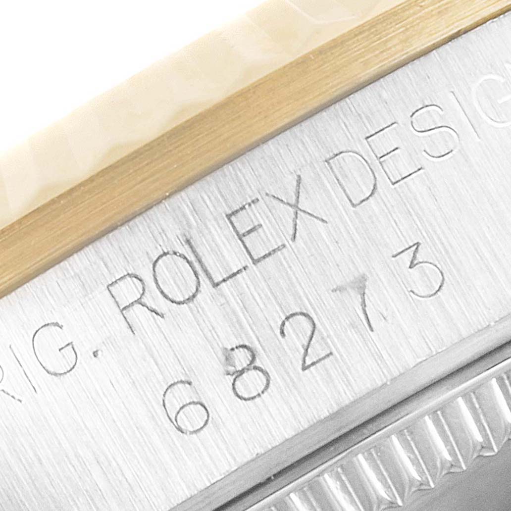 This is a close-up of the side of a Rolex Mid-Size 68273 Women's Steel and Gold (two tone) Champagne Dial 68273 Women's Steel and Gold (two tone) Champagne Dial watch, showing the engraved model number 68273 and part of the bezel.