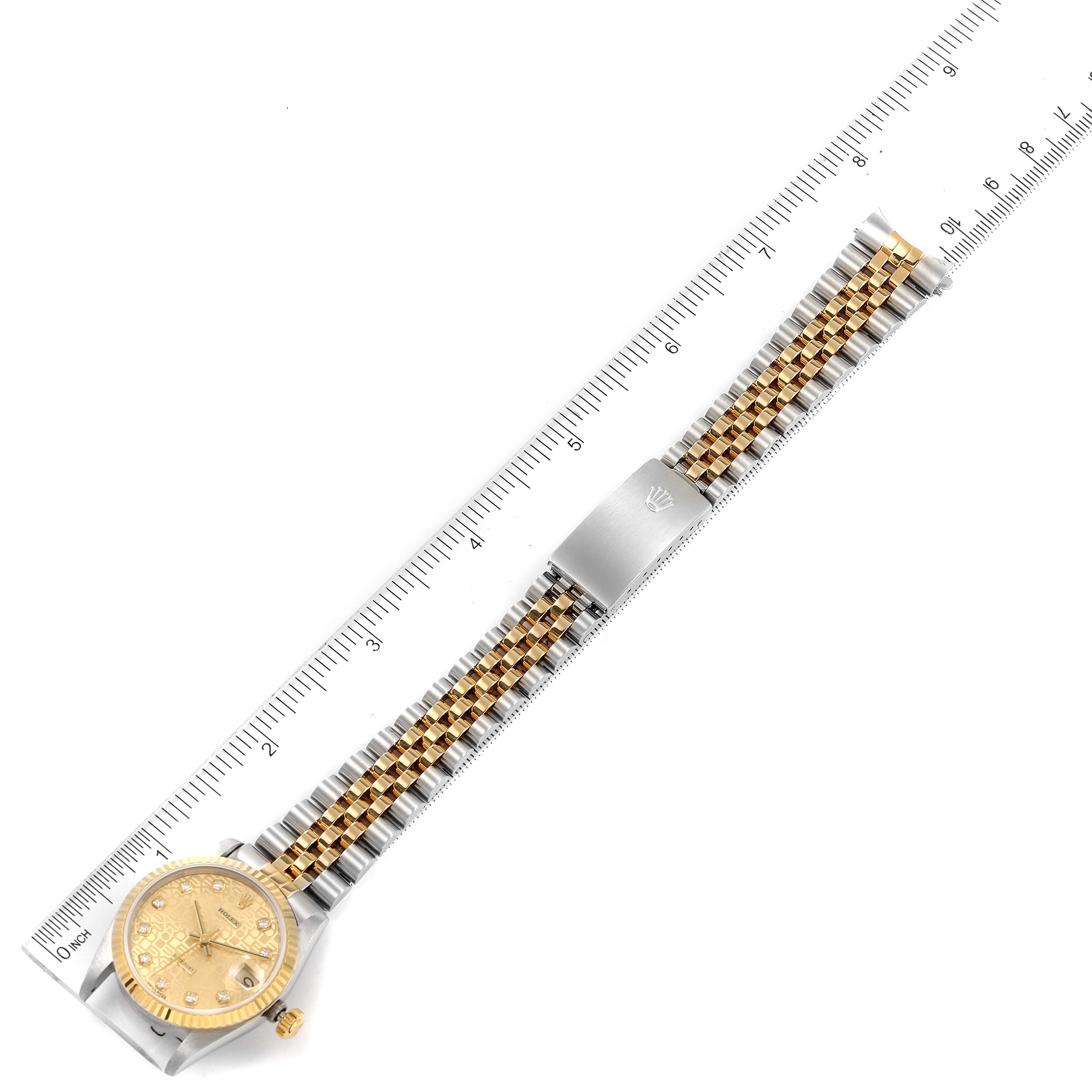 This image shows a full front view of a Rolex Mid-Size 68273 Women's Steel and Gold (two tone) Champagne Dial 68273 Women's Steel and Gold (two tone) Champagne Dial watch alongside a ruler.