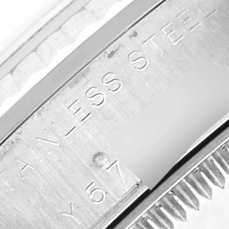 The image shows a close-up of the inner bezel and fluted edge of a Mid-Size Rolex watch.