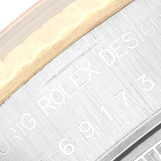Close-up of the side of a Rolex Datejust 69173 Women's Steel and Gold (two tone) Black Dial 69173 Women's Steel and Gold (two tone) Black Dial watch, showing the engraved "ROLEX DESIGN" and part of the bezel.