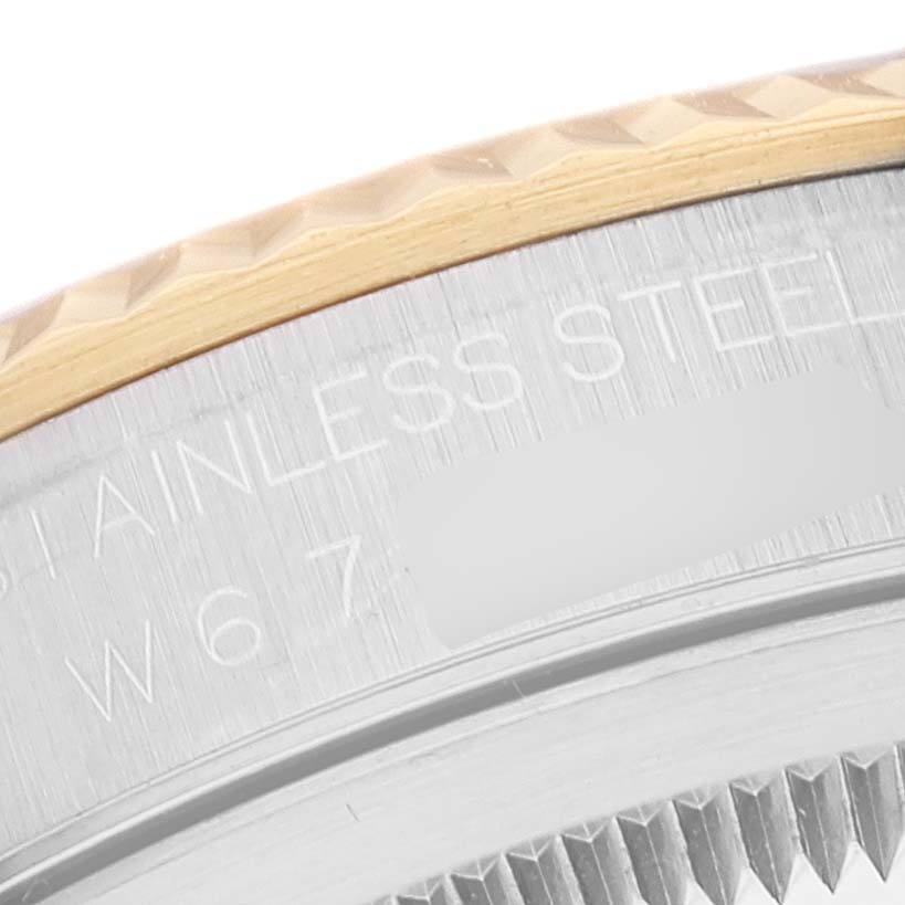 This is a close-up image of the bezel and part of the case back of a Rolex Datejust 16233 Men's Steel and Gold (two tone) Black Dial 16233 Men's Steel and Gold (two tone) Black Dial watch, showing text and fluted details.