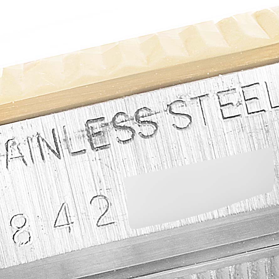 The image shows a close-up view of the case side of a Vintage Collection model by Rolex, highlighting the serial number and stainless steel text.