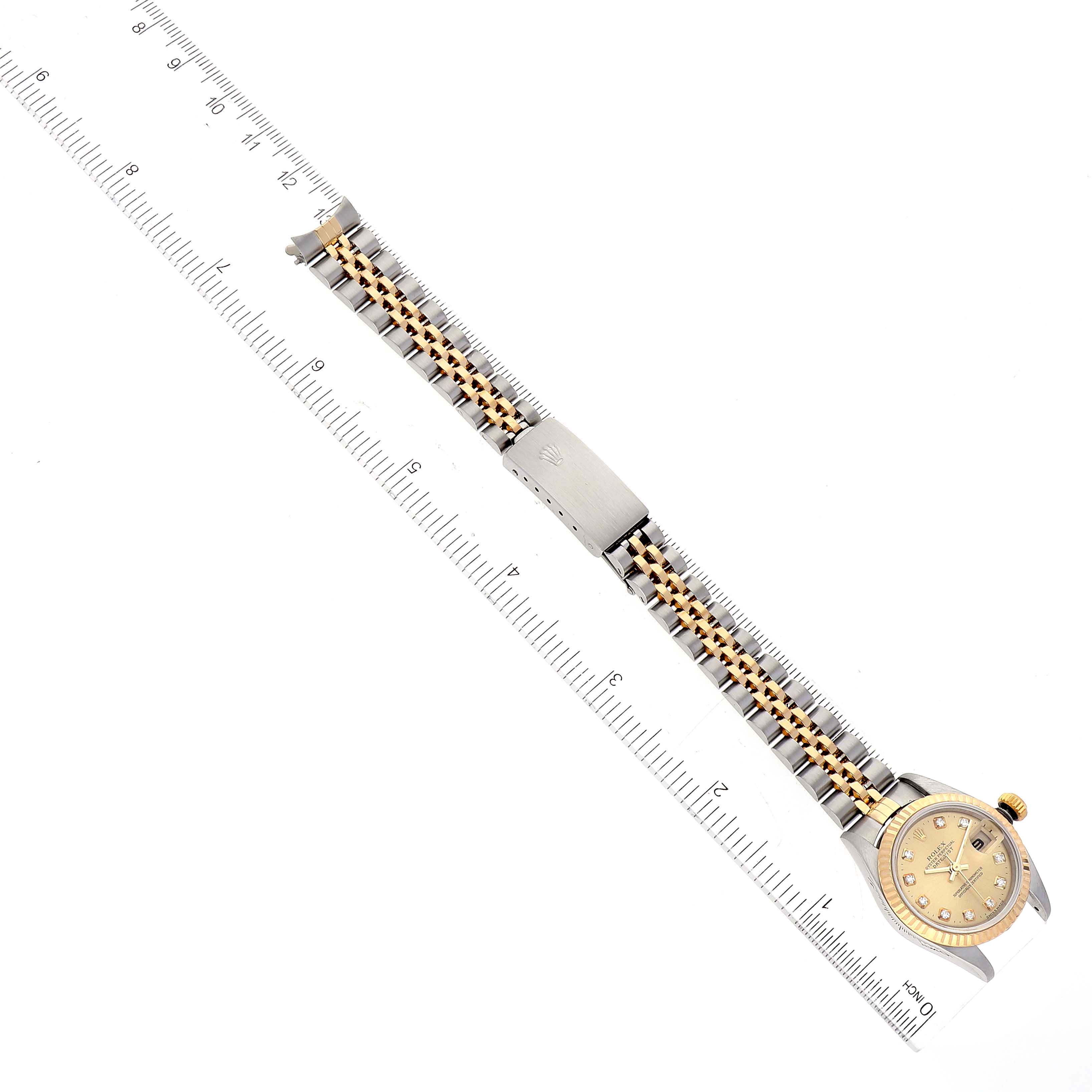 The image shows a Rolex Datejust 79173 Women's Steel and Gold (two tone) Champagne Dial 79173 Women's Steel and Gold (two tone) Champagne Dial watch laid flat next to a ruler, highlighting the bracelet and watch face.