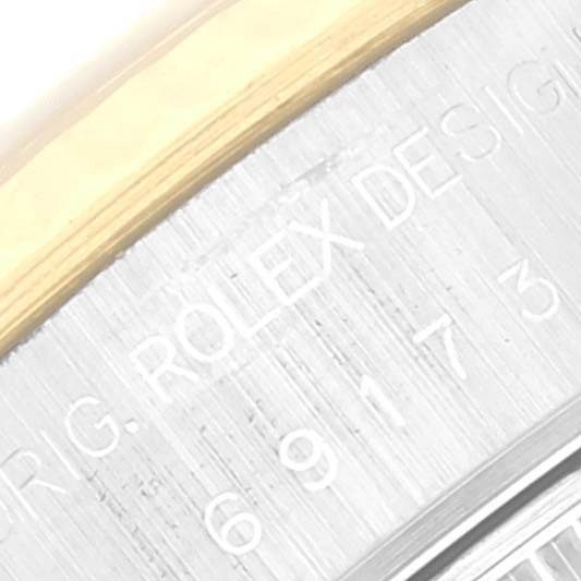 This image shows a close-up of the engraved side of the case of a Rolex Datejust 69173 Women's Steel and Gold (two tone) White Dial 69173 Women's Steel and Gold (two tone) White Dial watch.