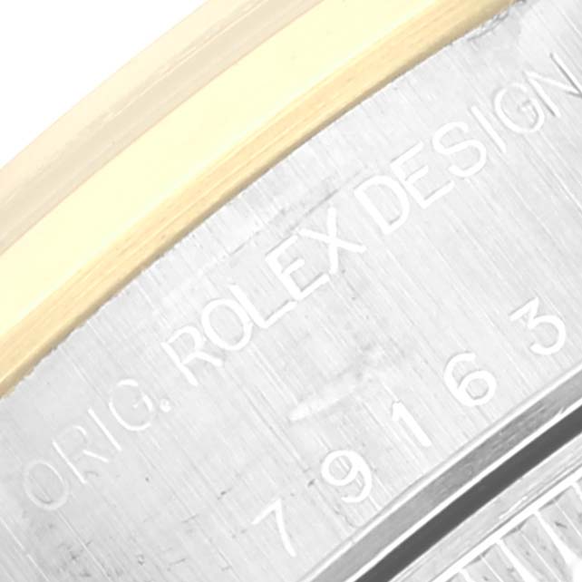 The image shows a close-up of the engraved serial number and design inscription on the case edge of a Rolex Datejust 79163 Women's Steel and Gold (two tone) Mother of Pearl Dial 79163 Women's Steel and Gold (two tone) Mother of Pearl Dial watch.