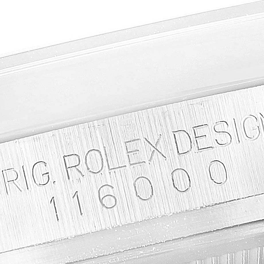 This image shows an engraved side of the bezel on a Rolex Oyster Perpetual 116000 Men's Stainless Steel Champagne Dial 116000 Men's Stainless Steel Champagne Dial model, displaying the serial number.