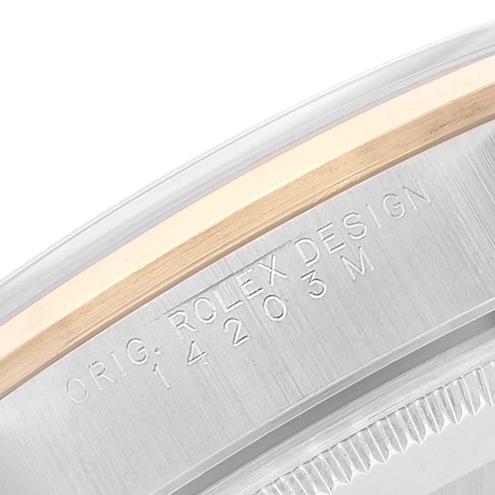 Close-up of the Oyster Perpetual Rolex watch bezel and case edge, showing model number and "ROLEX DESIGN" engraving.